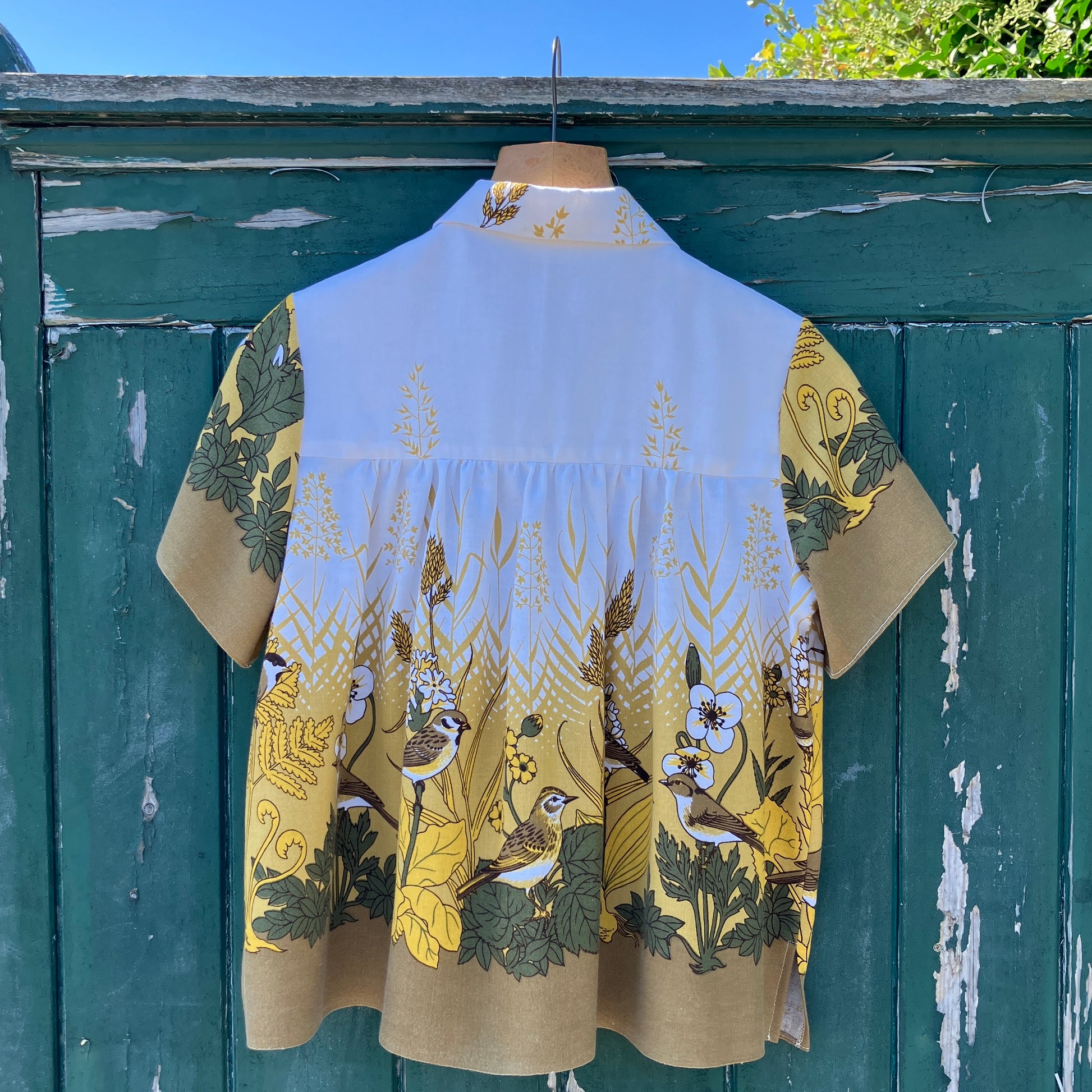 Shirt made from a recycled vintage 70s tablecloth featuring birds, birds nests, leaves, flowers and sheaves of wheat.