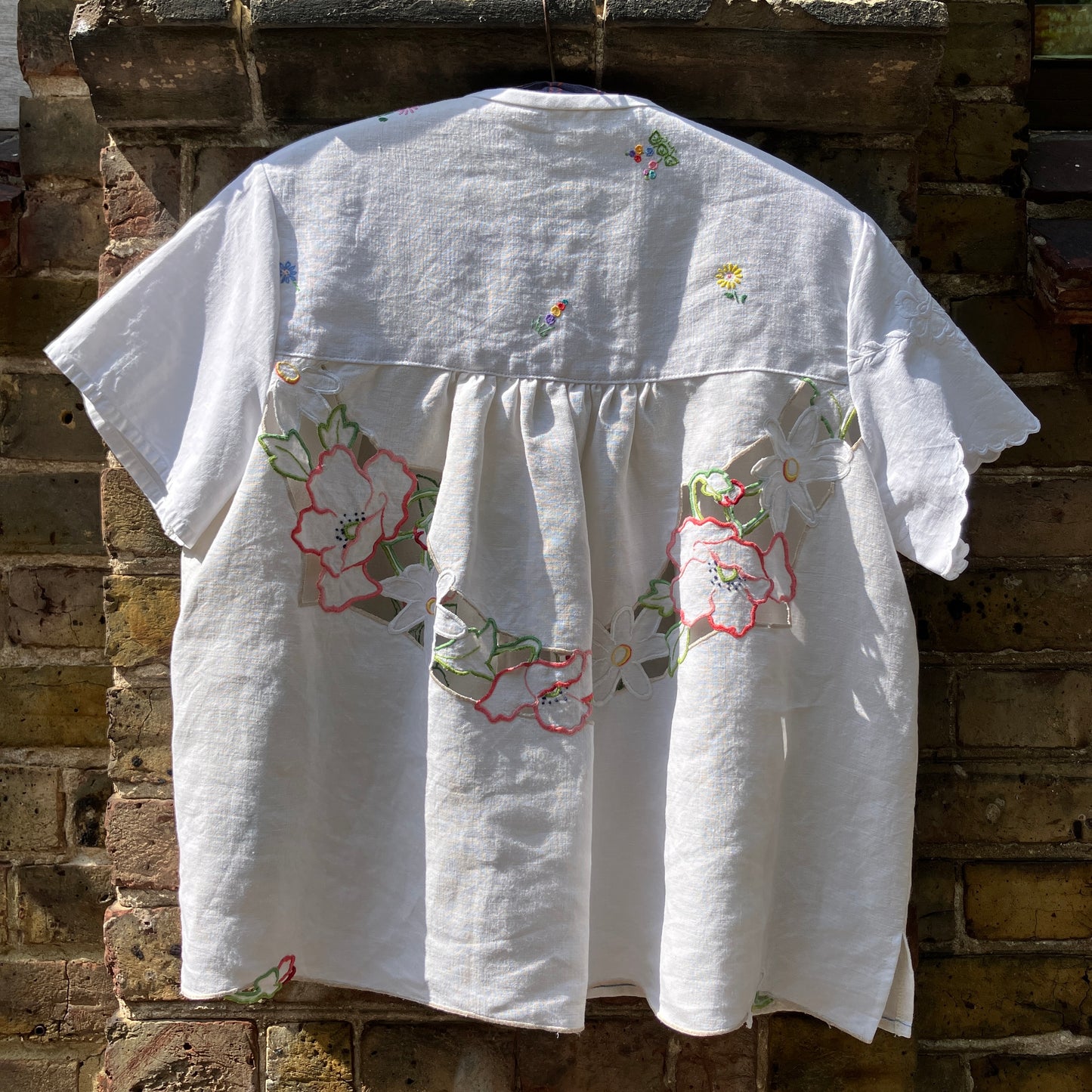 Swingy top made from found repurposed vintage tablecloths with embroidery and cutwork motifs.