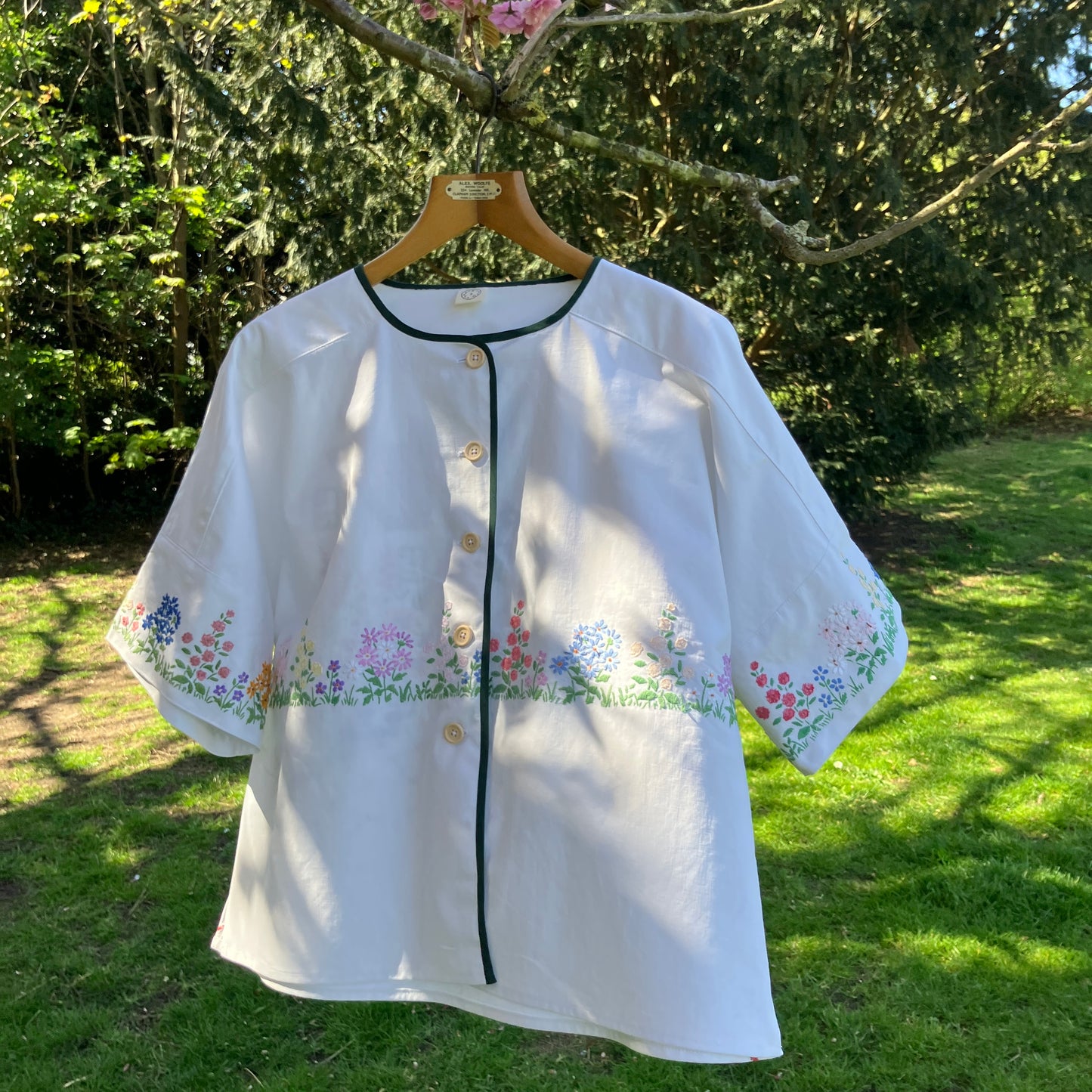 boxy top with embroidered flowers across the front and round the sleeves - and a country cottage on the back