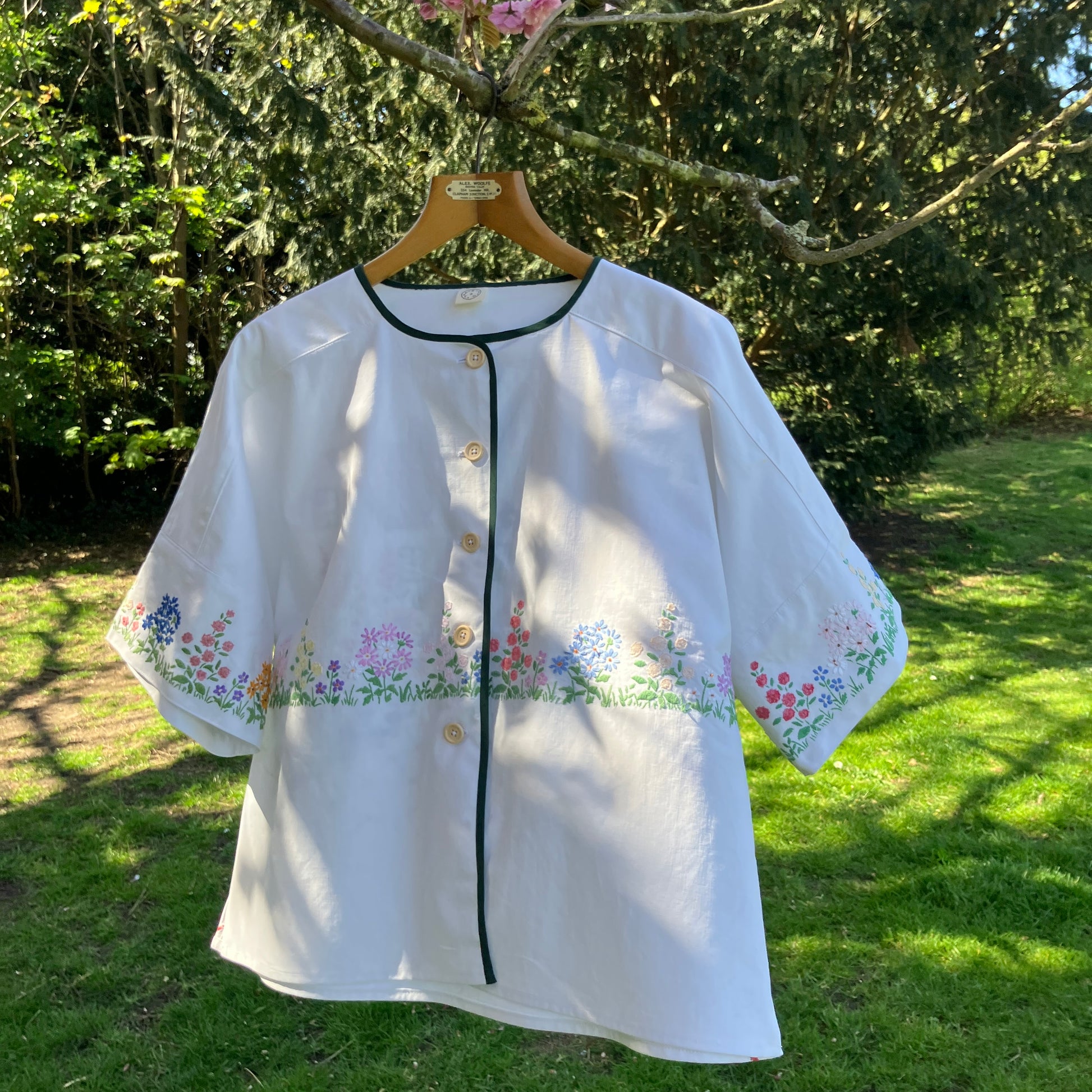 boxy top with embroidered flowers across the front and round the sleeves - and a country cottage on the back