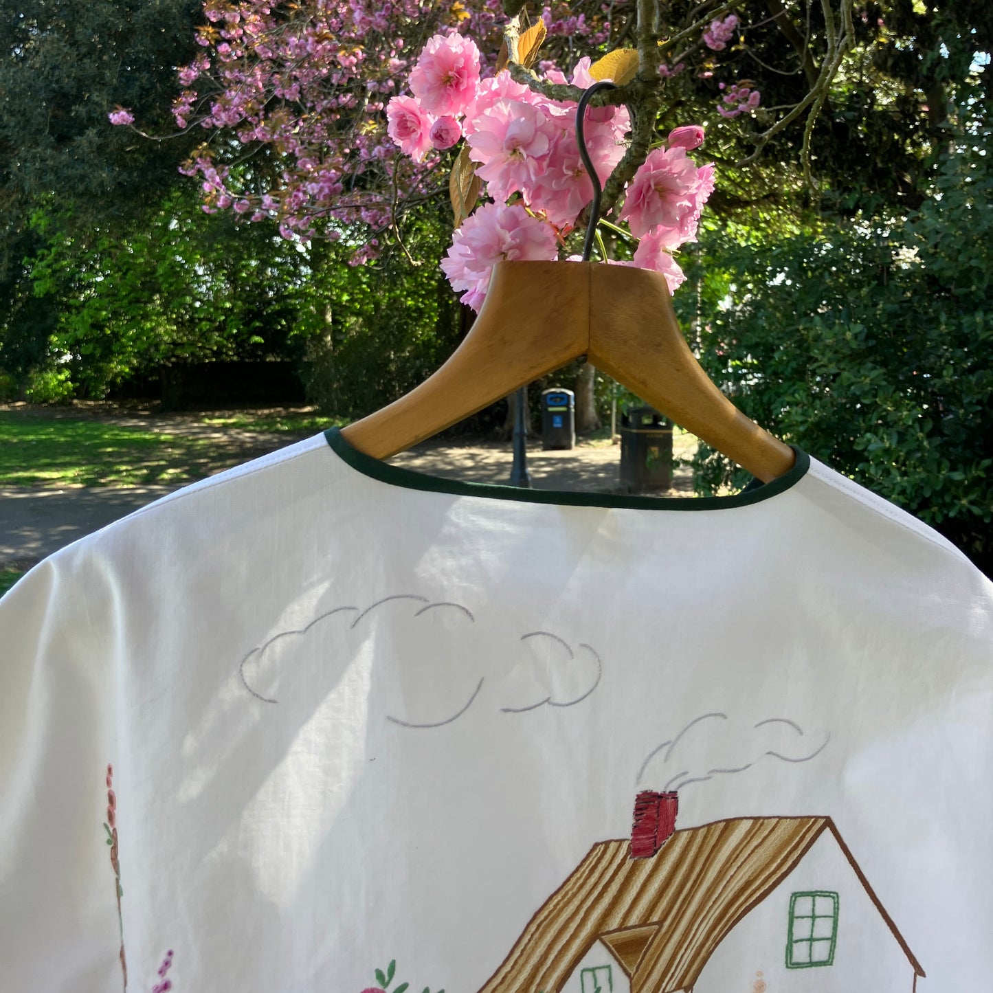 boxy top with embroidered flowers across the front and round the sleeves - and a country cottage on the back