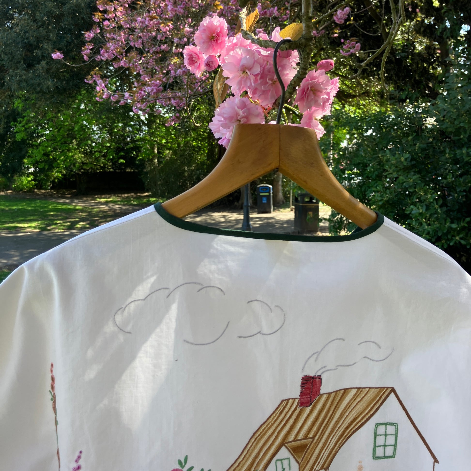 boxy top with embroidered flowers across the front and round the sleeves - and a country cottage on the back
