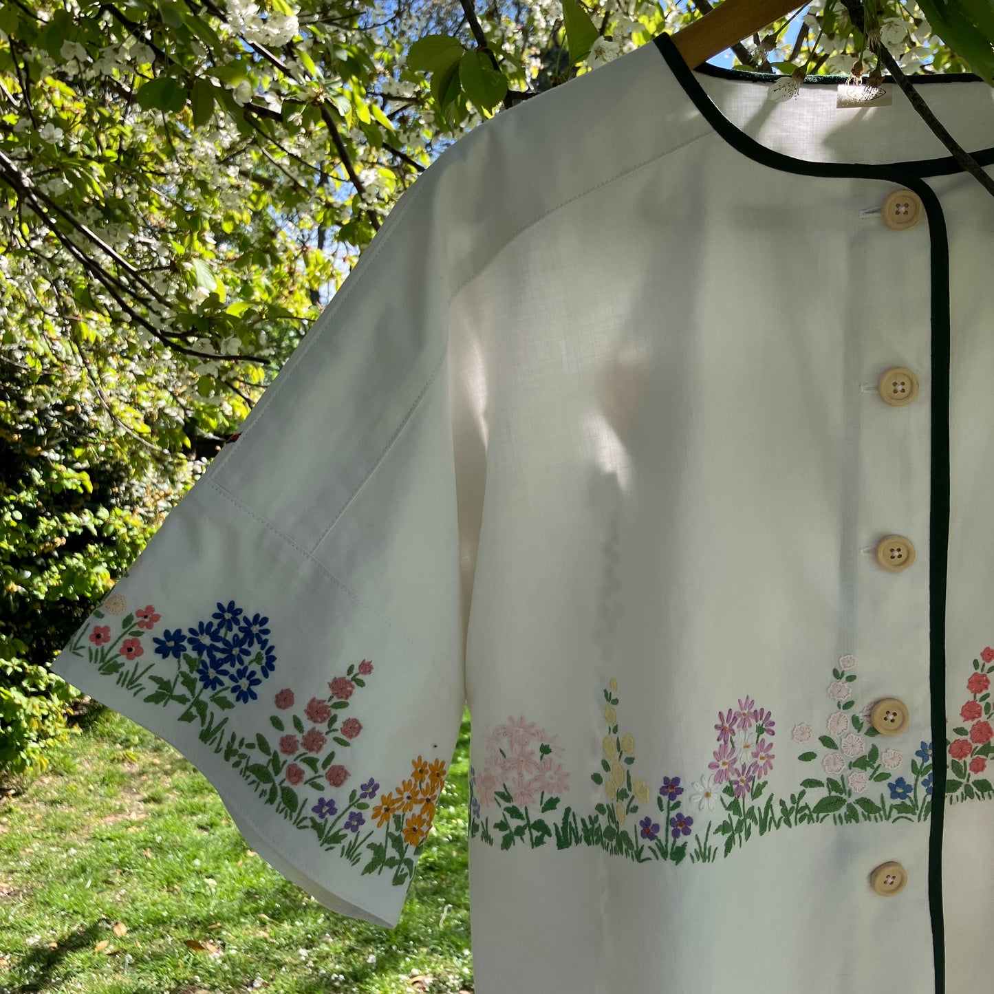 boxy top with embroidered flowers across the front and round the sleeves - and a country cottage on the back