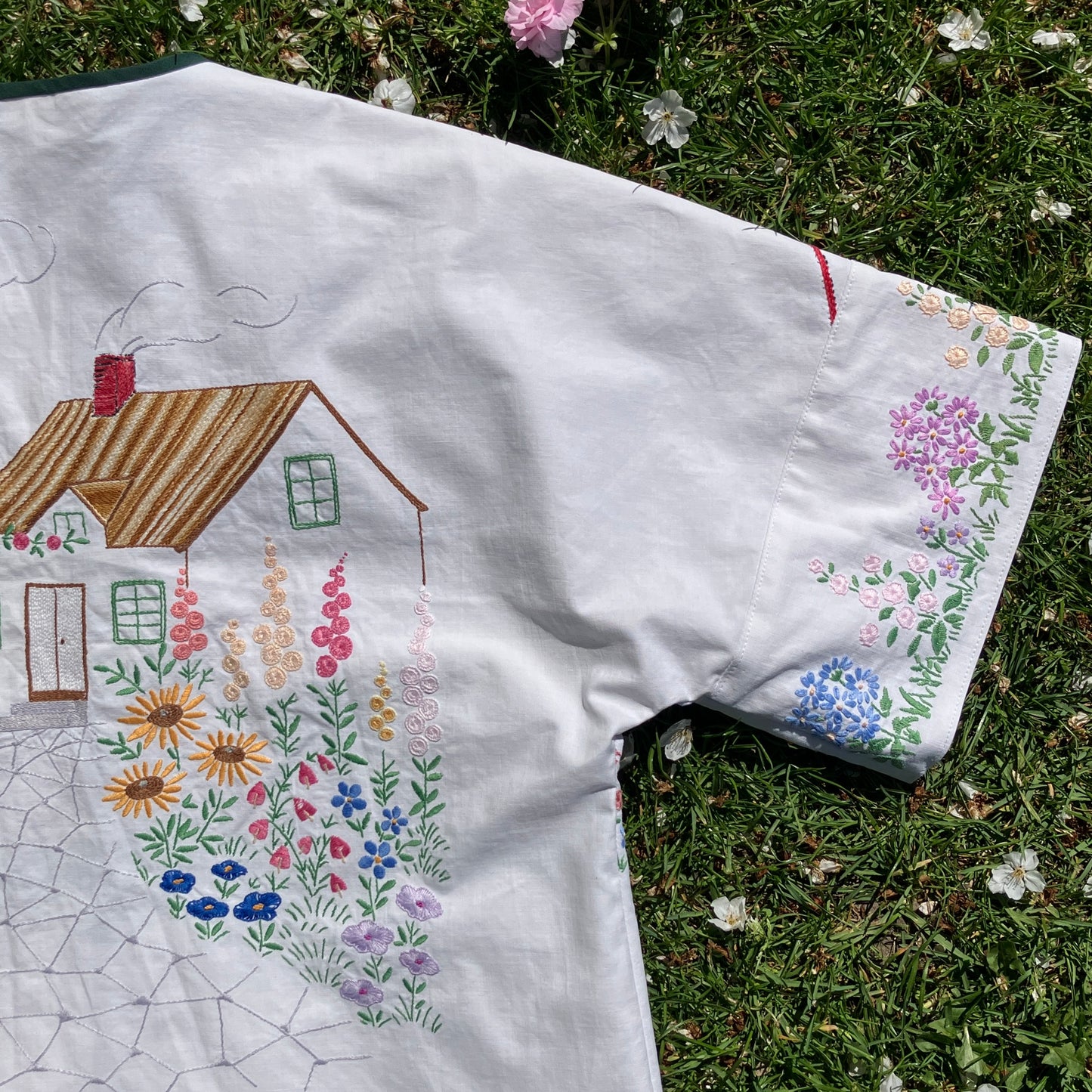 boxy top with embroidered flowers across the front and round the sleeves - and a country cottage on the back