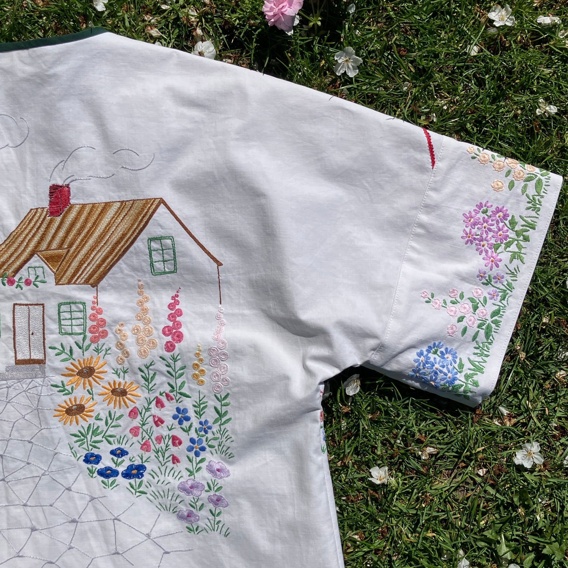 boxy top with embroidered flowers across the front and round the sleeves - and a country cottage on the back