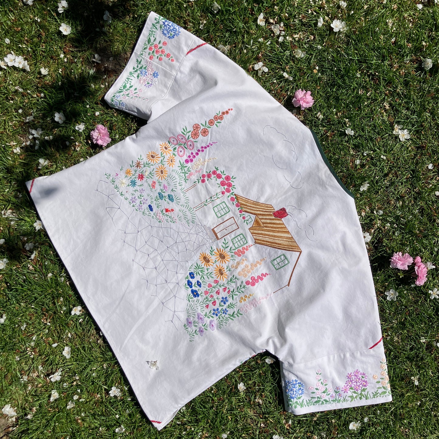 boxy top with embroidered flowers across the front and round the sleeves - and a country cottage on the back