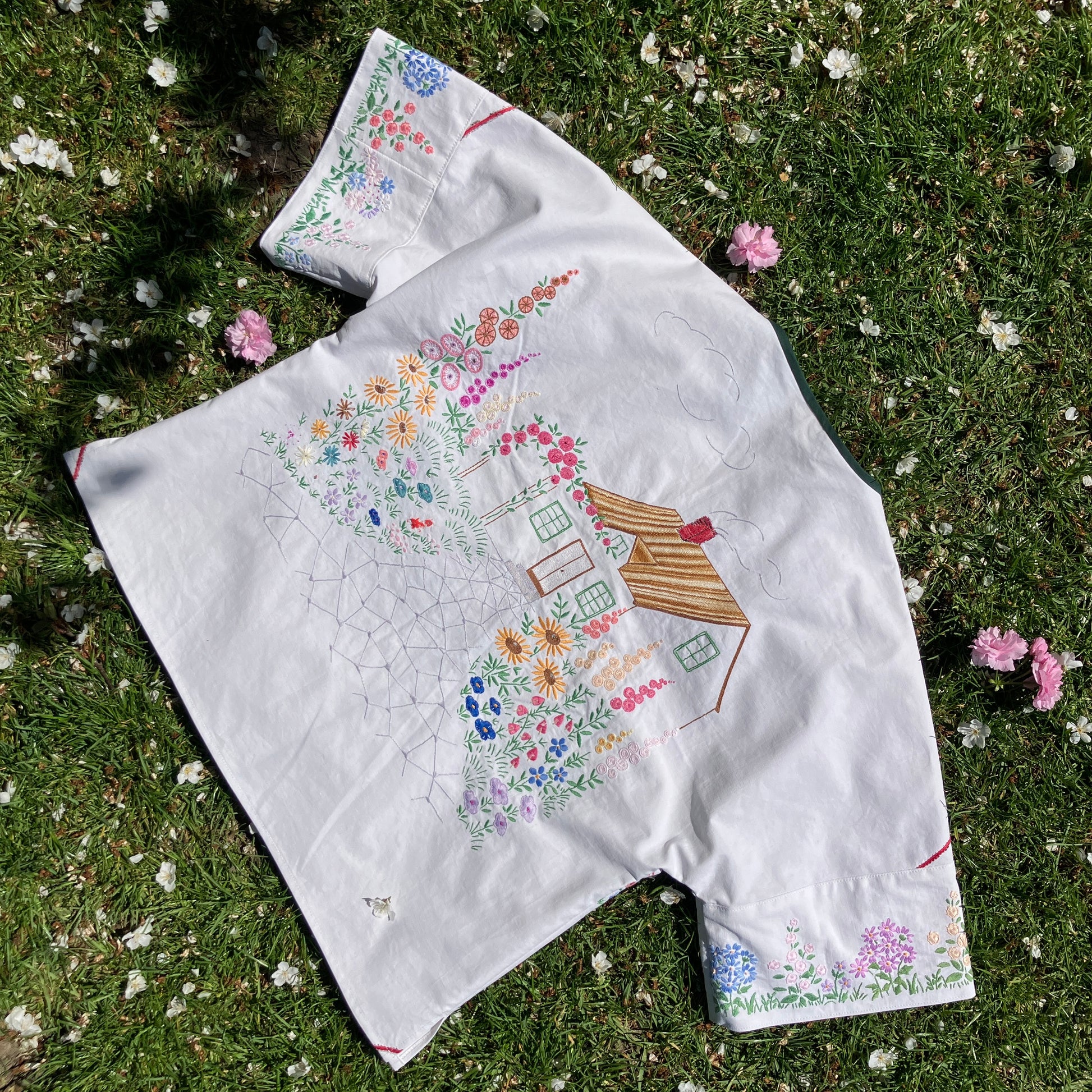 boxy top with embroidered flowers across the front and round the sleeves - and a country cottage on the back