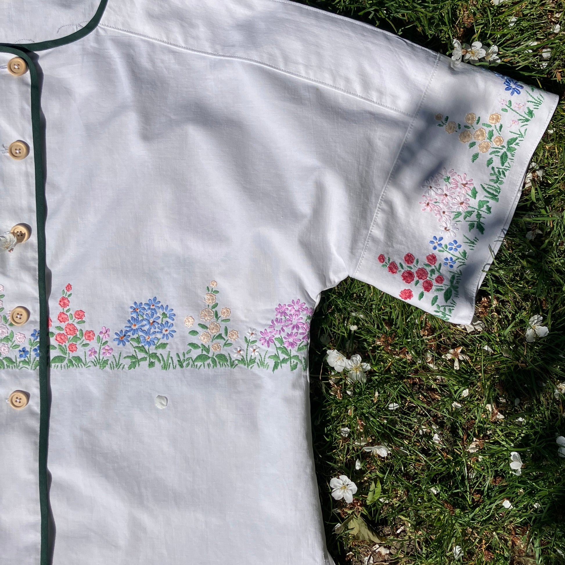 boxy top with embroidered flowers across the front and round the sleeves - and a country cottage on the back