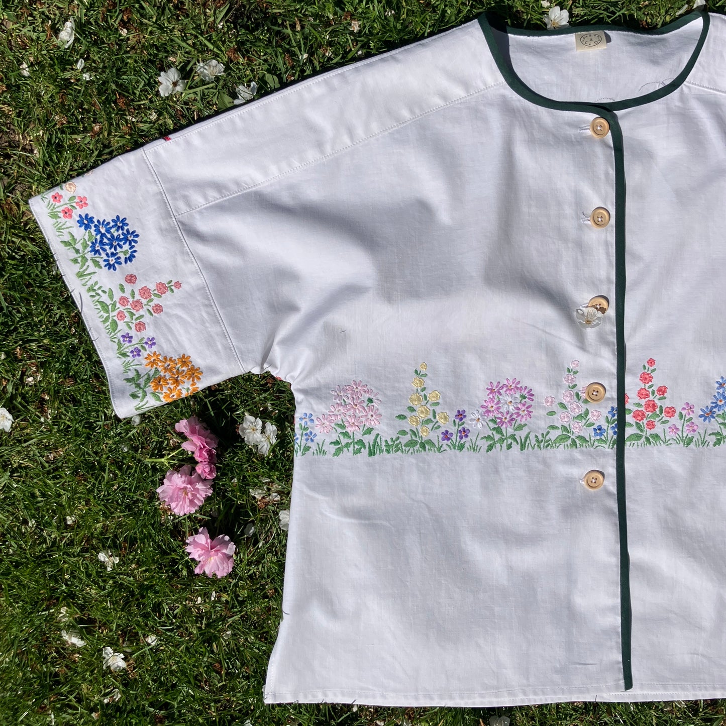 boxy top with embroidered flowers across the front and round the sleeves - and a country cottage on the back