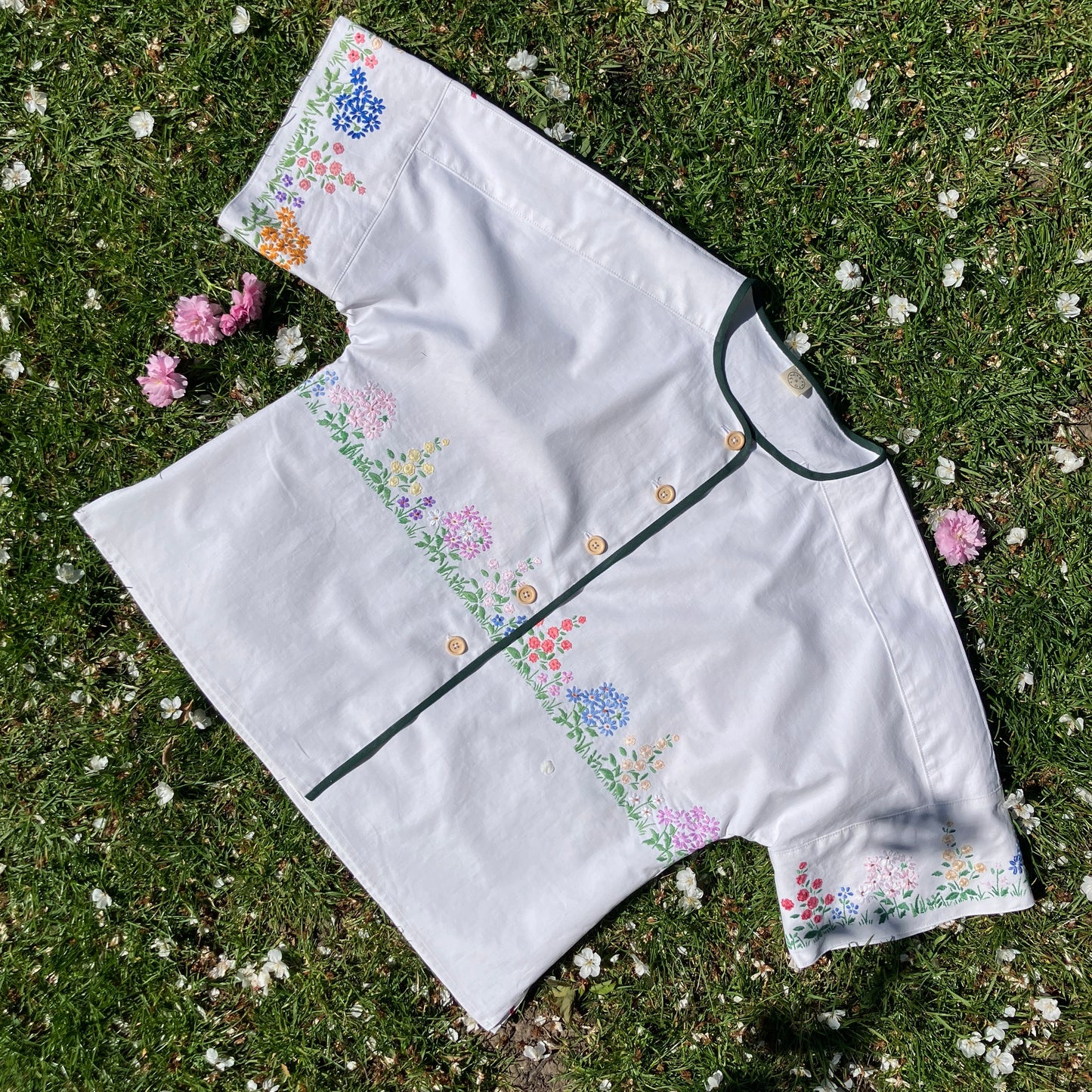boxy top with embroidered flowers across the front and round the sleeves - and a country cottage on the back