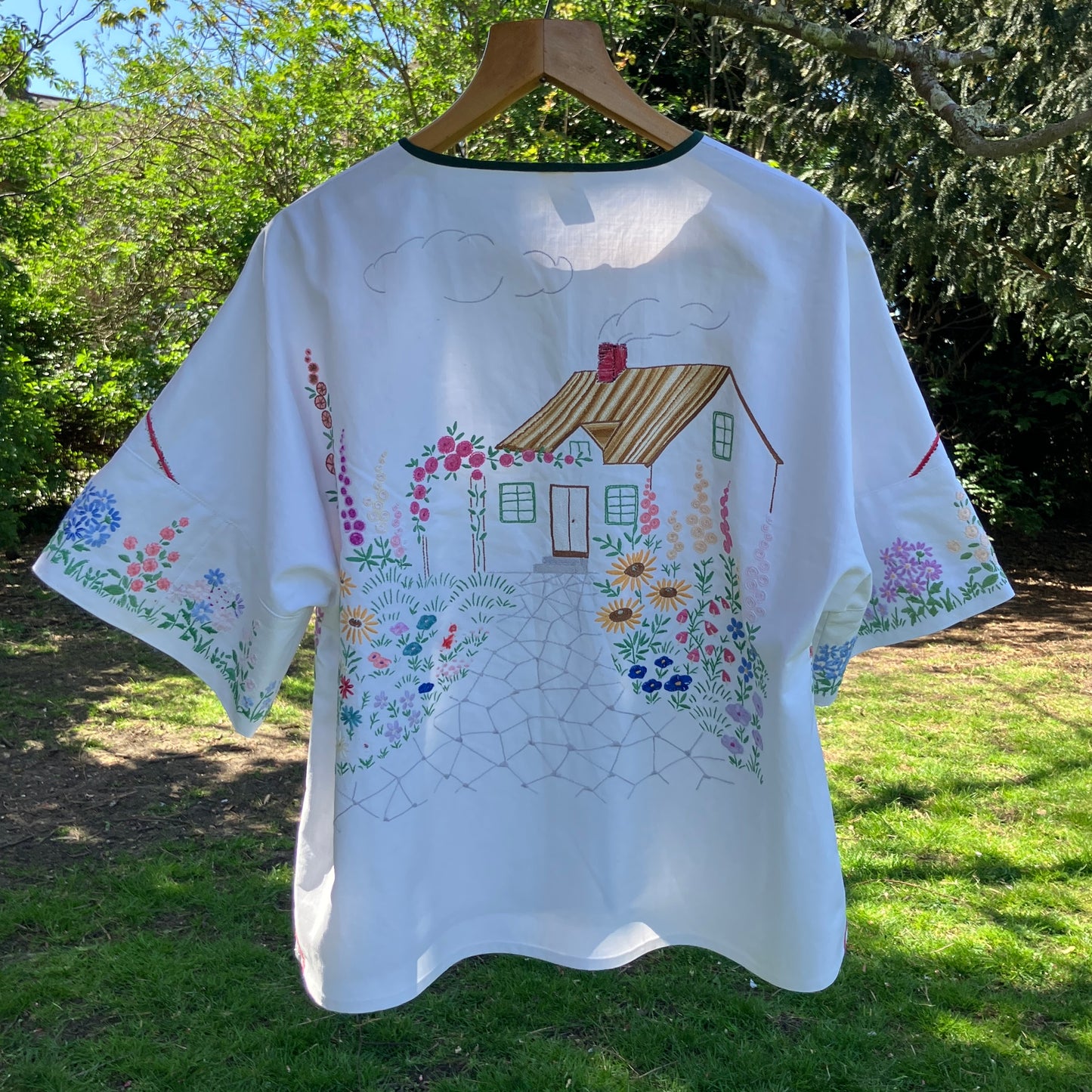 boxy top with embroidered flowers across the front and round the sleeves - and a country cottage on the back