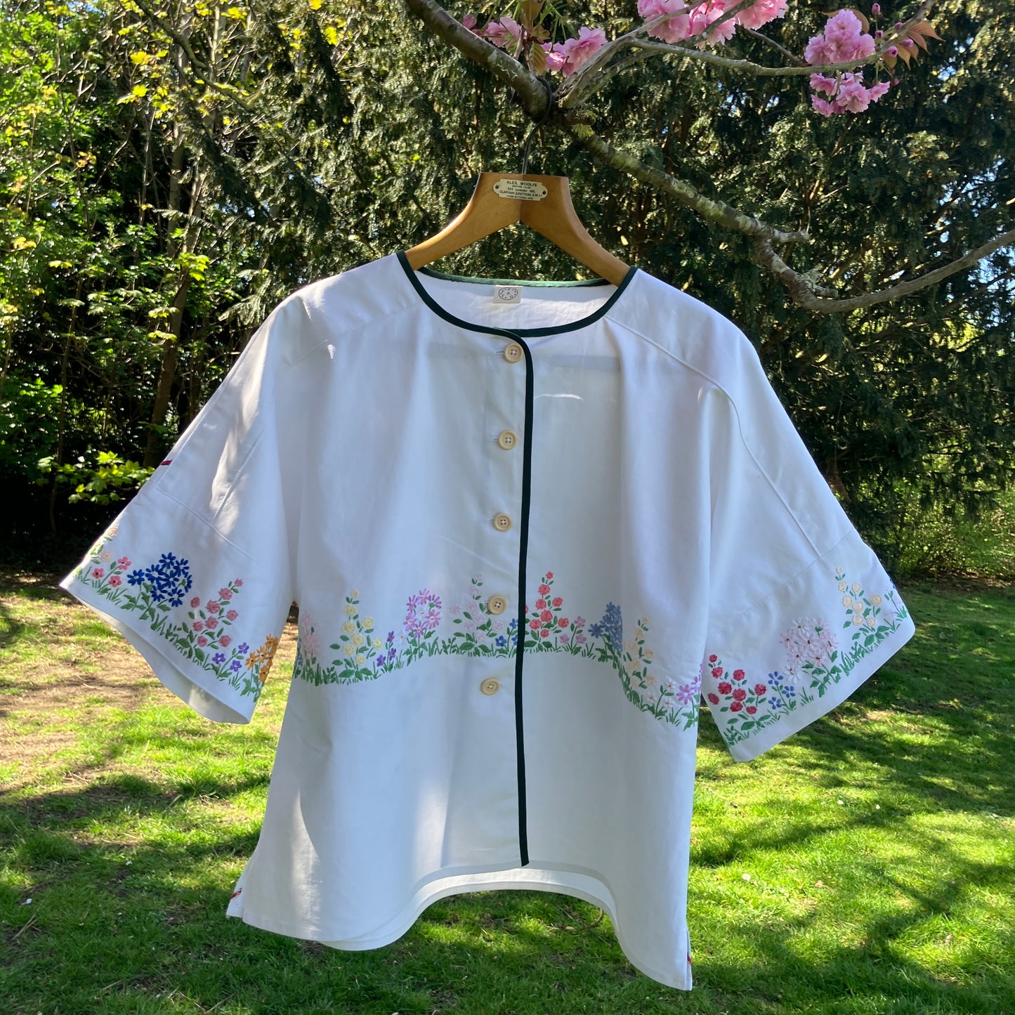 boxy top with embroidered flowers across the front and round the sleeves - and a country cottage on the back