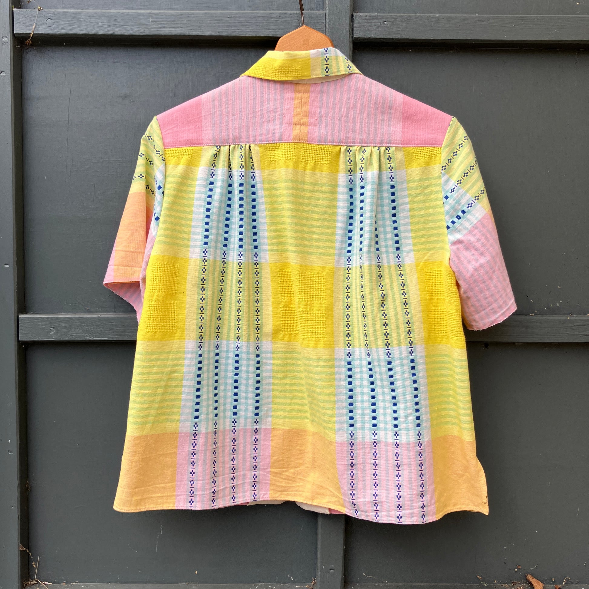 Shirt made from a reclaimed cotton tablecloth in shades of pink, blue, peach and bright yellow