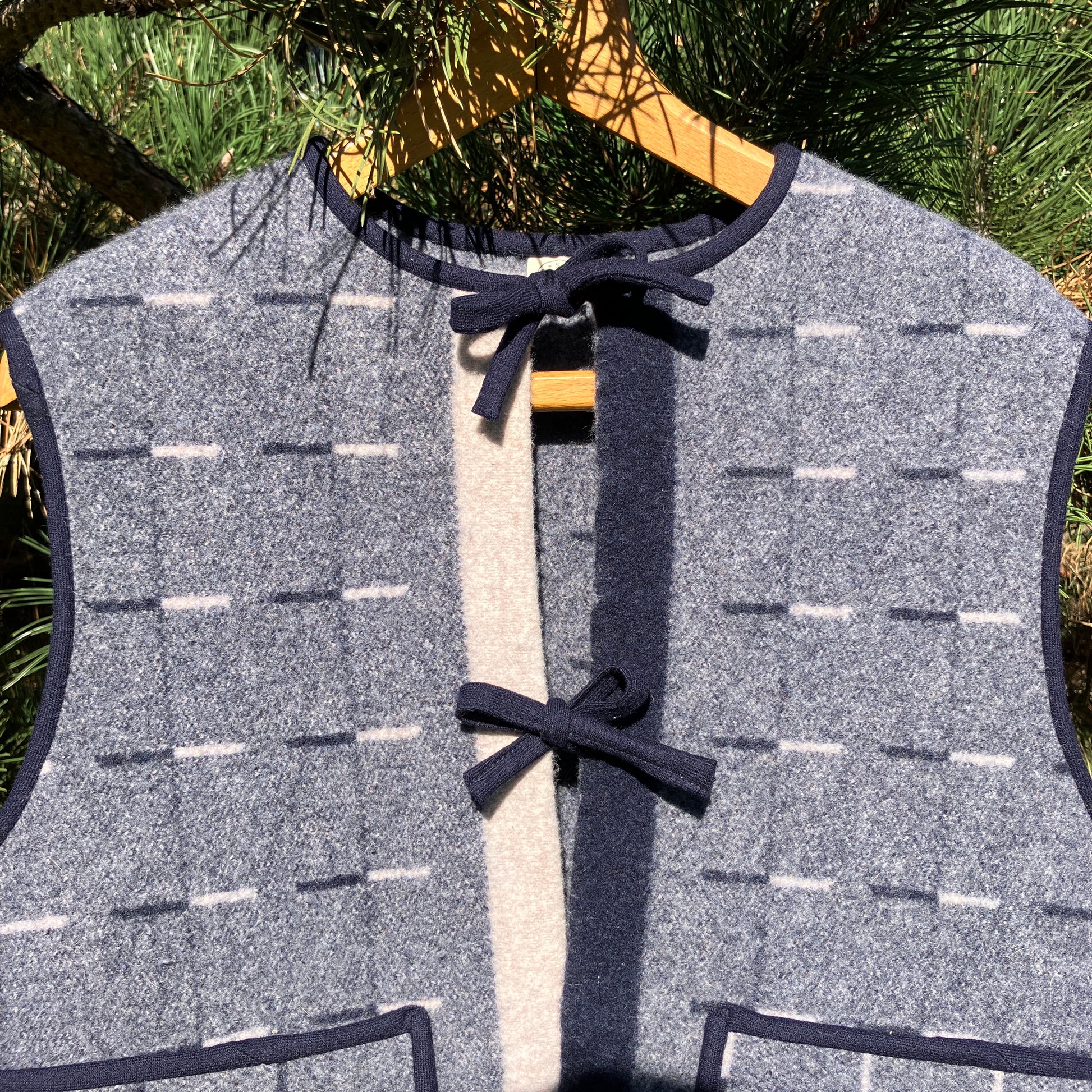Cosy vest made from a reclaimed grey and blue lambswool blanket with two tie fastenings