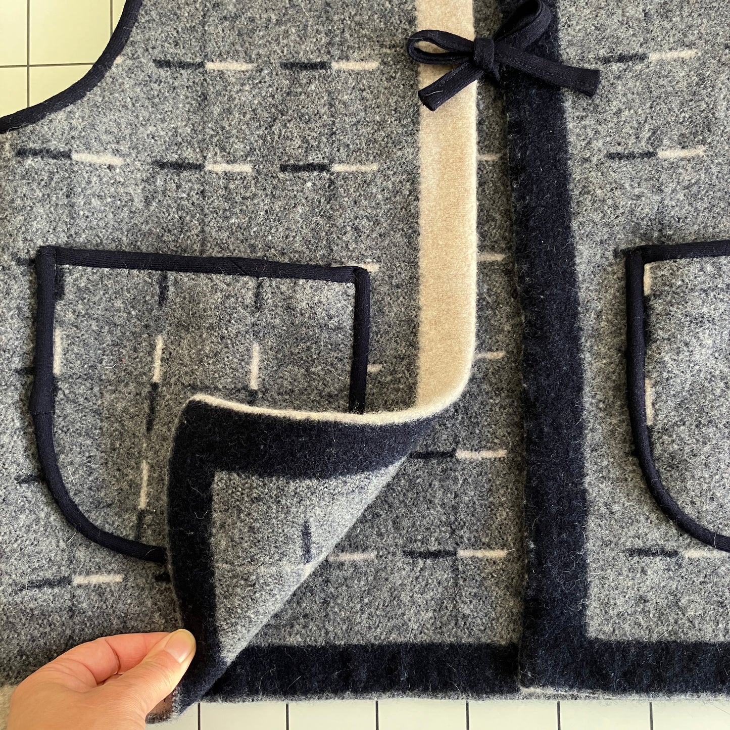 Cosy vest made from a reclaimed grey and blue lambswool blanket with two tie fastenings