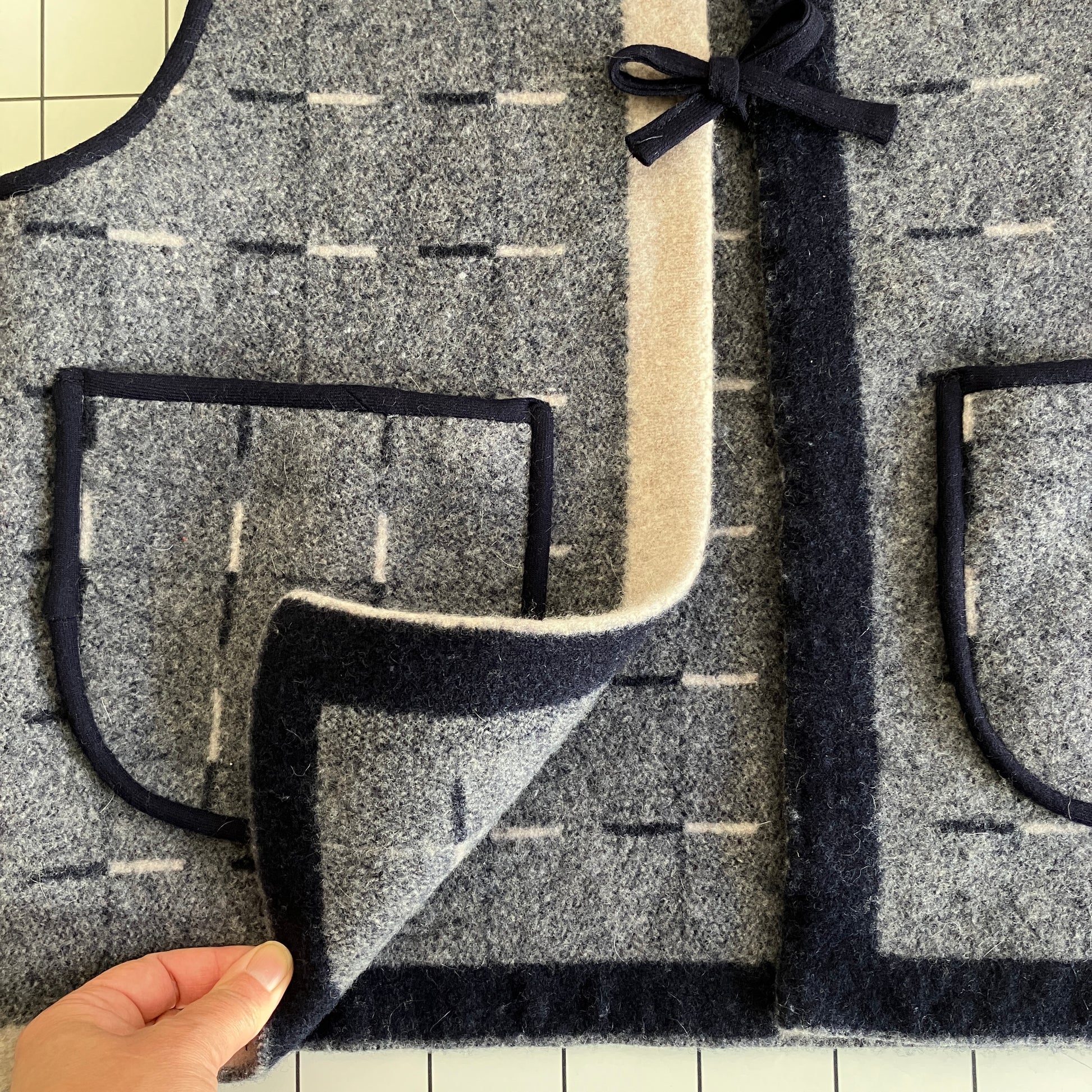 Cosy vest made from a reclaimed grey and blue lambswool blanket with two tie fastenings