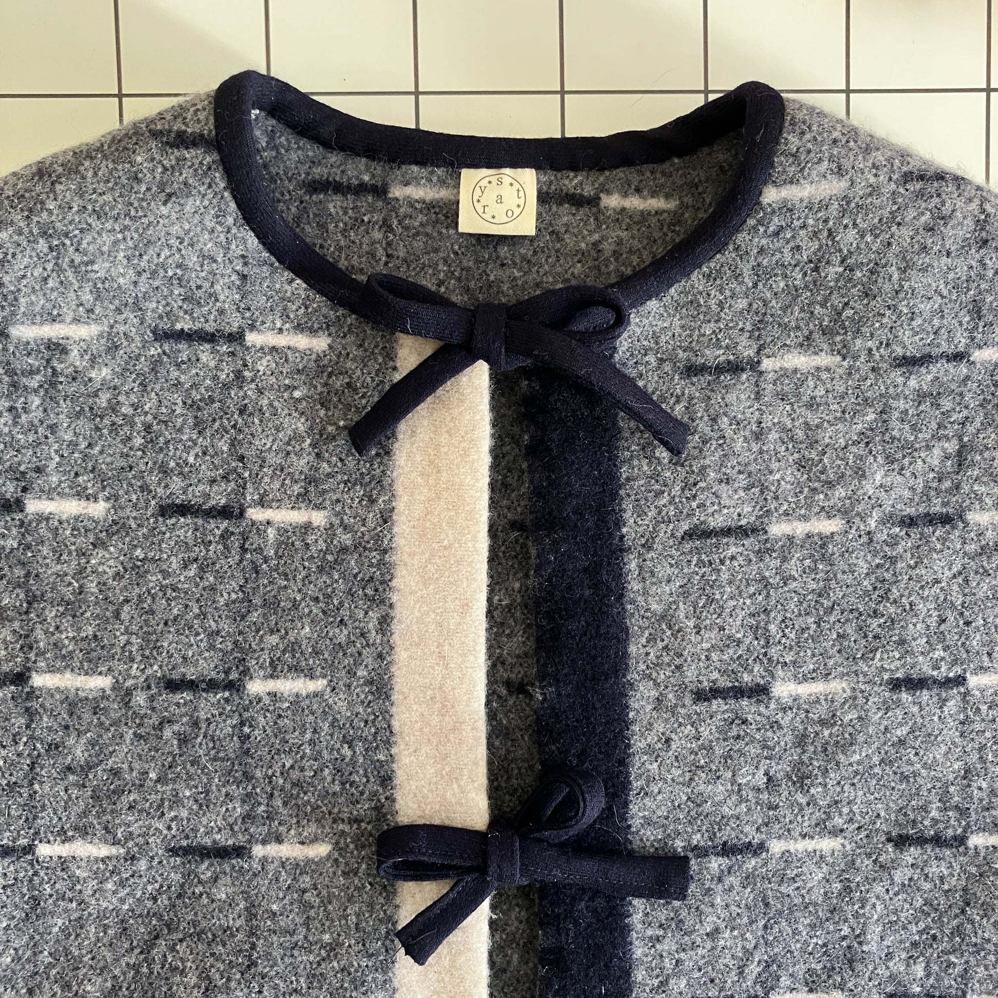 Cosy vest made from a reclaimed grey and blue lambswool blanket with two tie fastenings