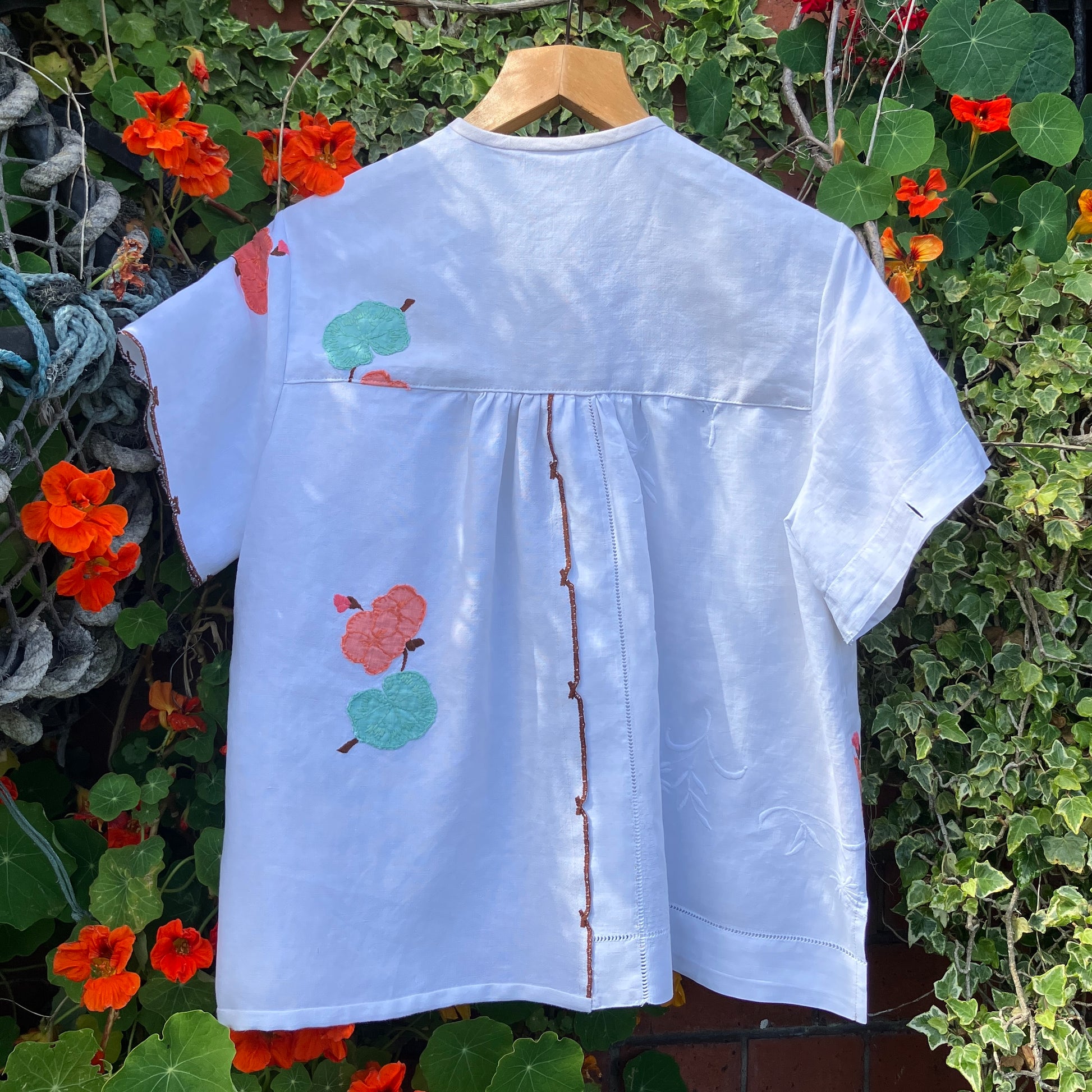 summer top hand made from a reclaimed tablecloth with appliqué nasturtiums in red, orange, peach and green (back view)