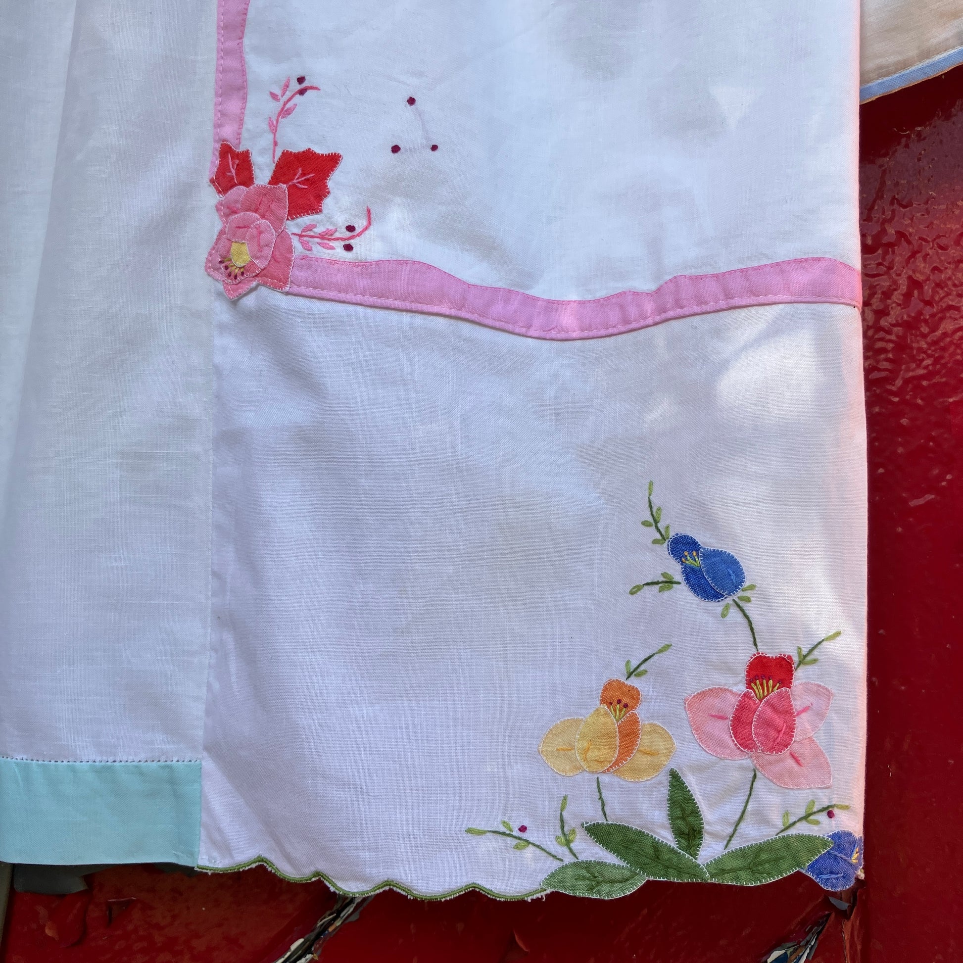 linen and cotton shirt made from a patchwork of reclaimed vintage napkins and placemats with detailed appliqué flowers and pastel borders