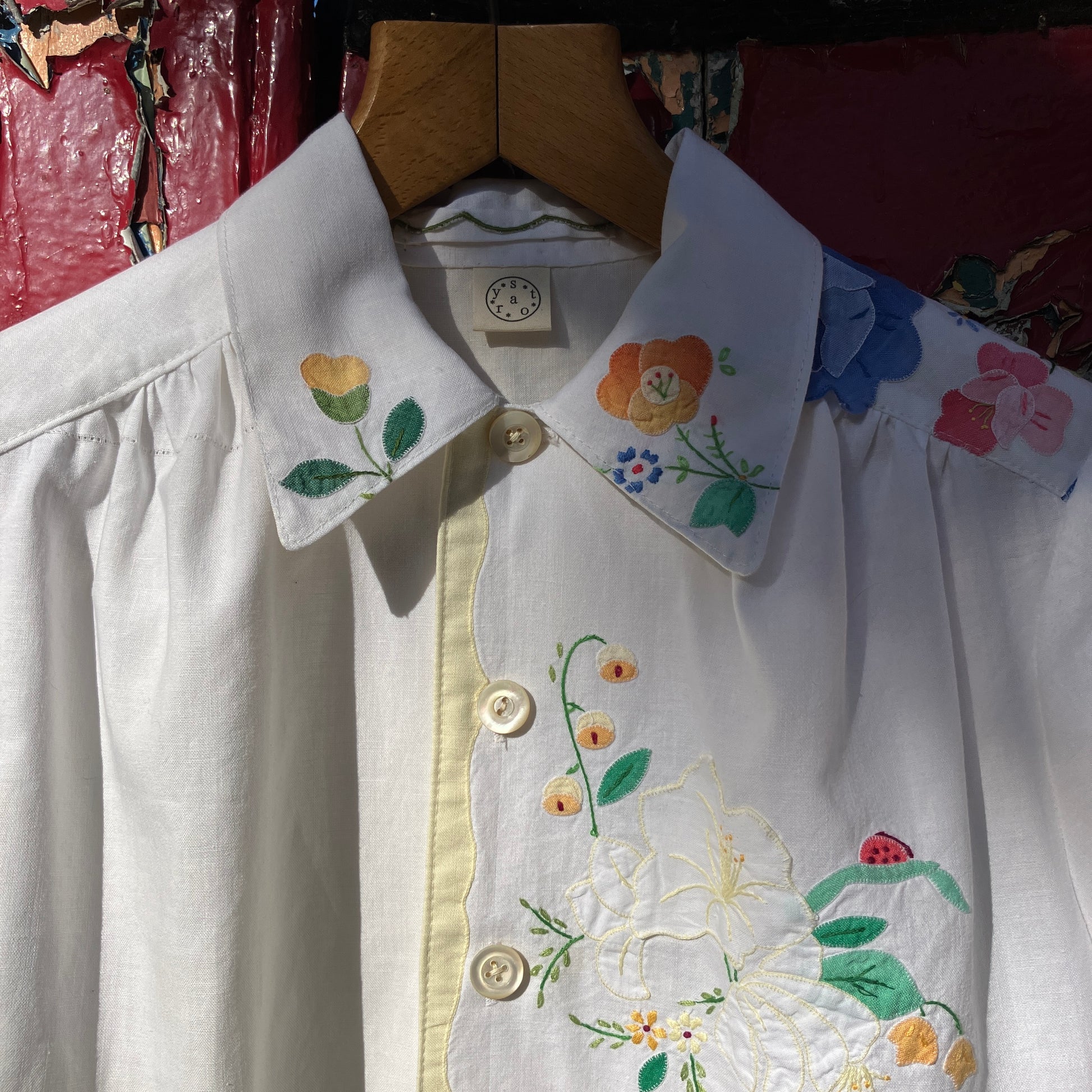 linen and cotton shirt made from a patchwork of reclaimed vintage napkins and placemats with detailed appliqué flowers and pastel borders