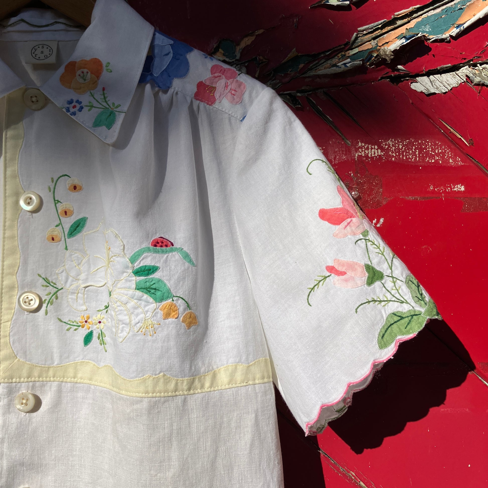 linen and cotton shirt made from a patchwork of reclaimed vintage napkins and placemats with detailed appliqué flowers and pastel borders