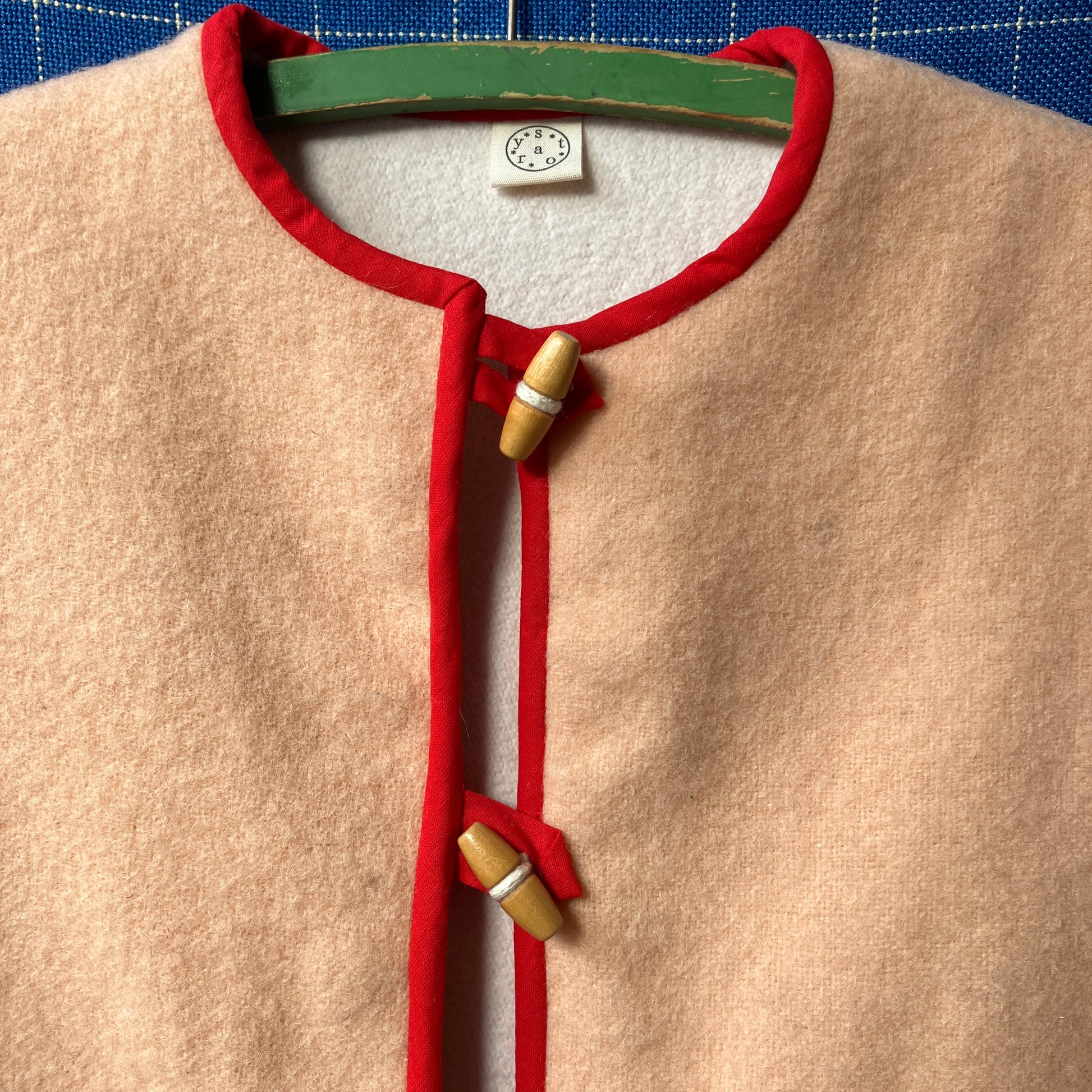 Vest/waistcoat made from a recycled vintage pink wool blanket, with red cotton binding and vintage wooden toggles