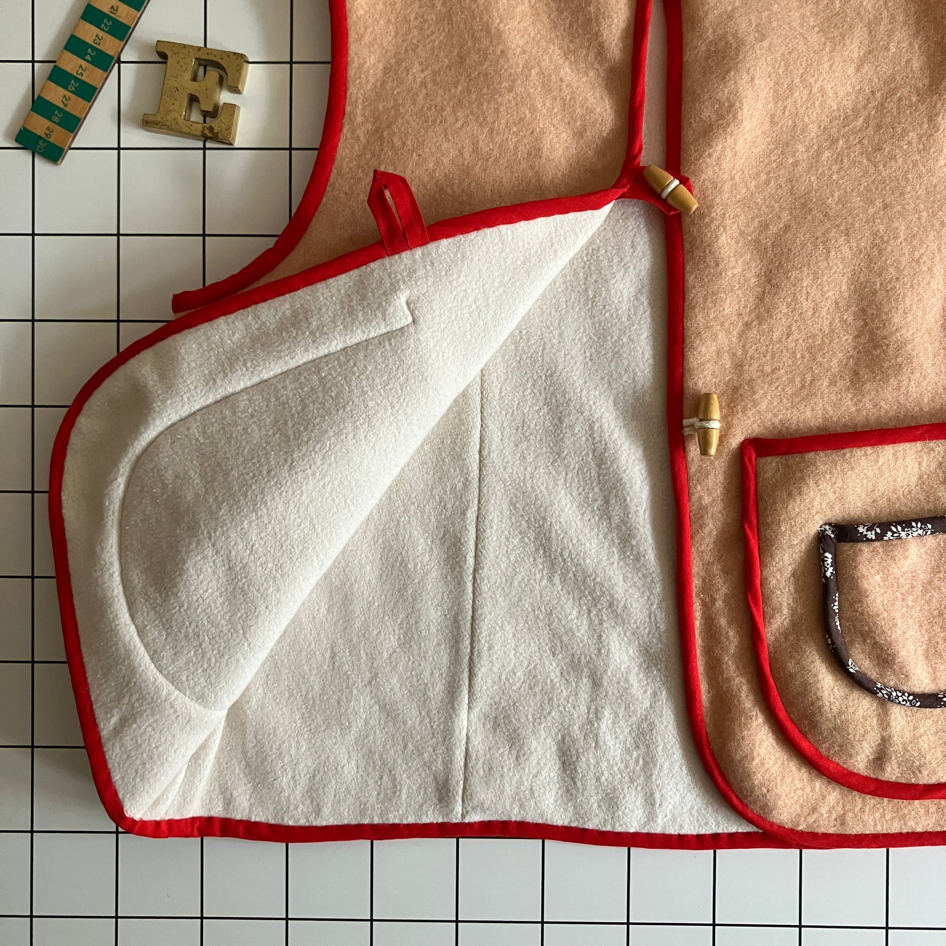 Vest/waistcoat made from a recycled vintage pink wool blanket, with red cotton binding and vintage wooden toggles