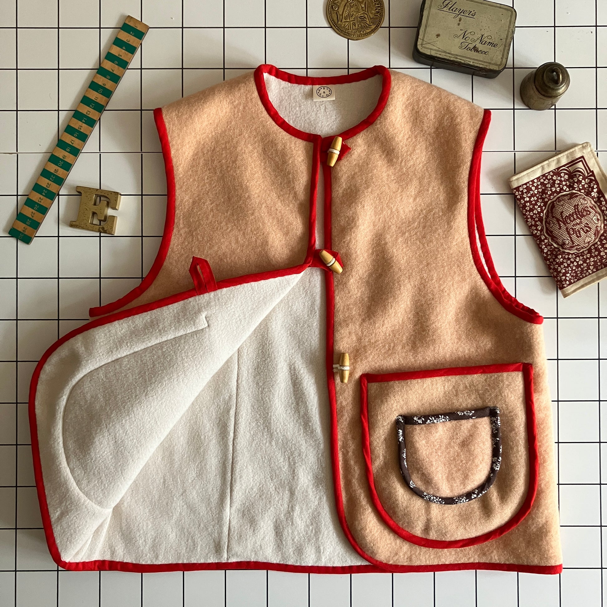Vest/waistcoat made from a recycled vintage pink wool blanket, with red cotton binding and vintage wooden toggles