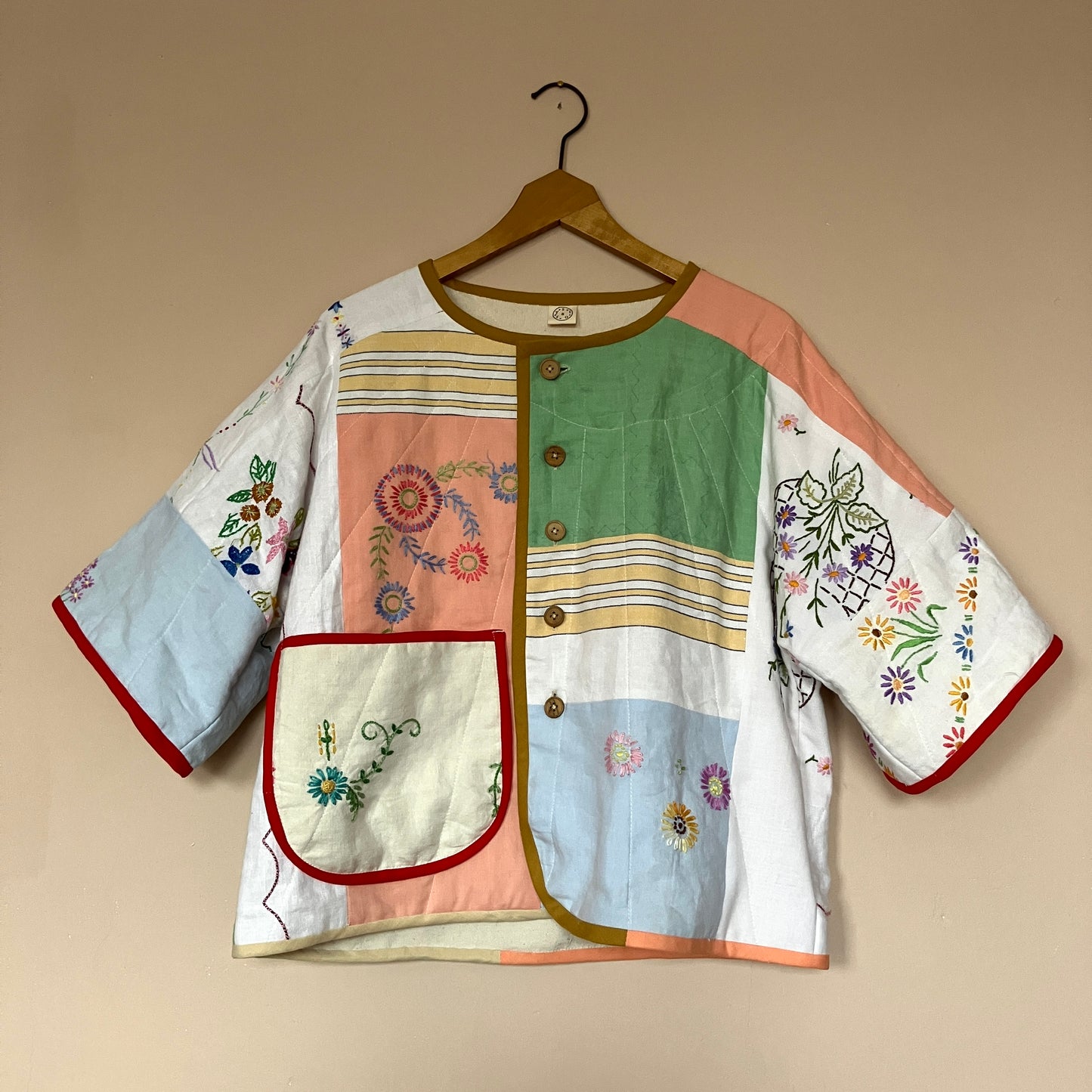 quilted top or jacket made from a patchwork of vintage tablecloths