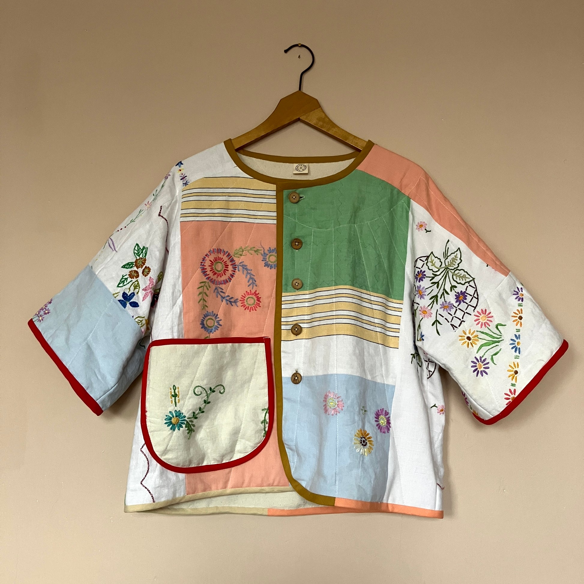 quilted top or jacket made from a patchwork of vintage tablecloths