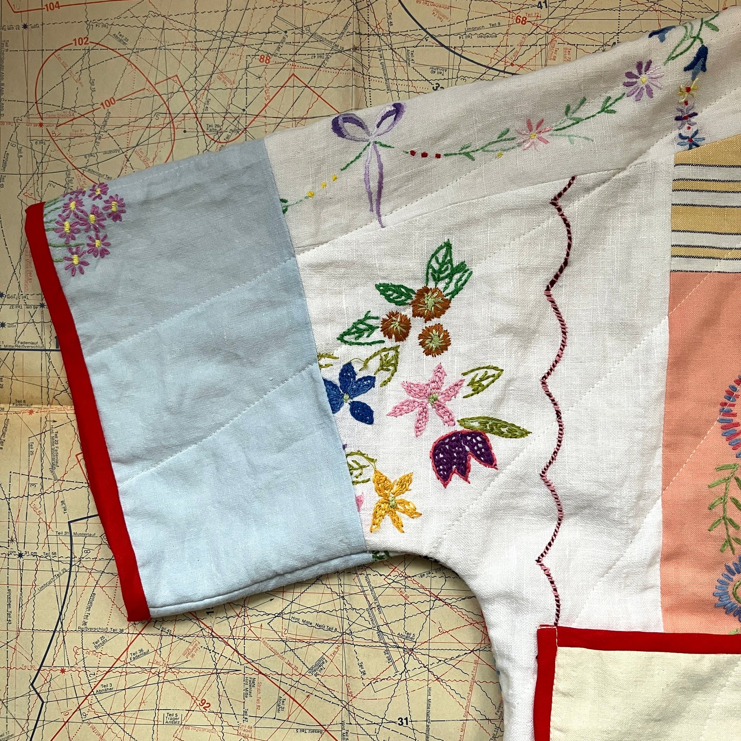 quilted top or jacket made from a patchwork of vintage tablecloths