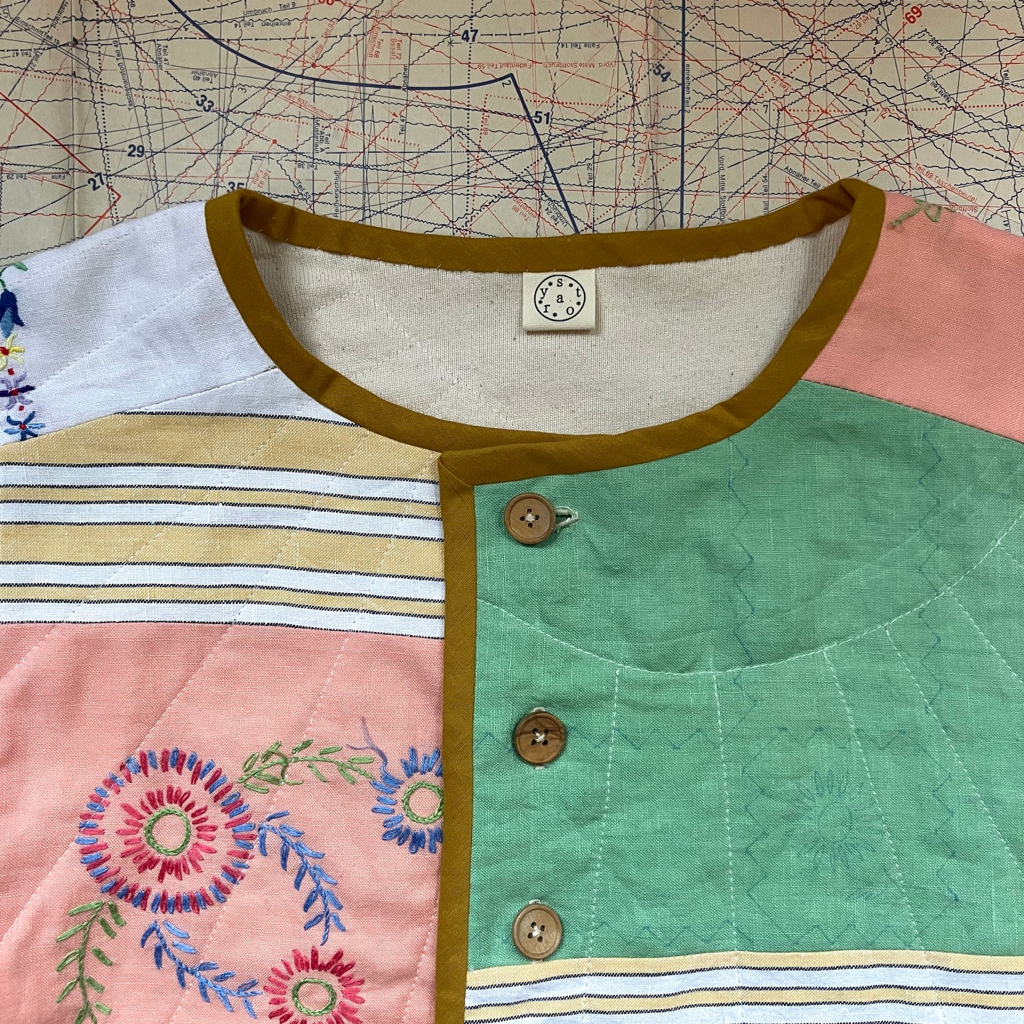 quilted top or jacket made from a patchwork of vintage tablecloths