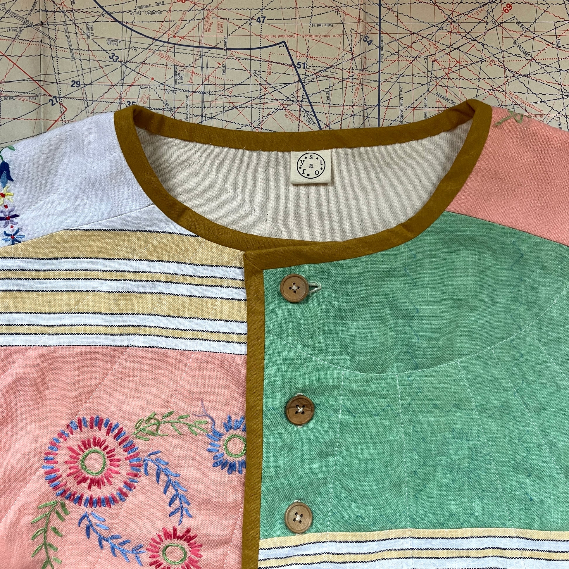 quilted top or jacket made from a patchwork of vintage tablecloths
