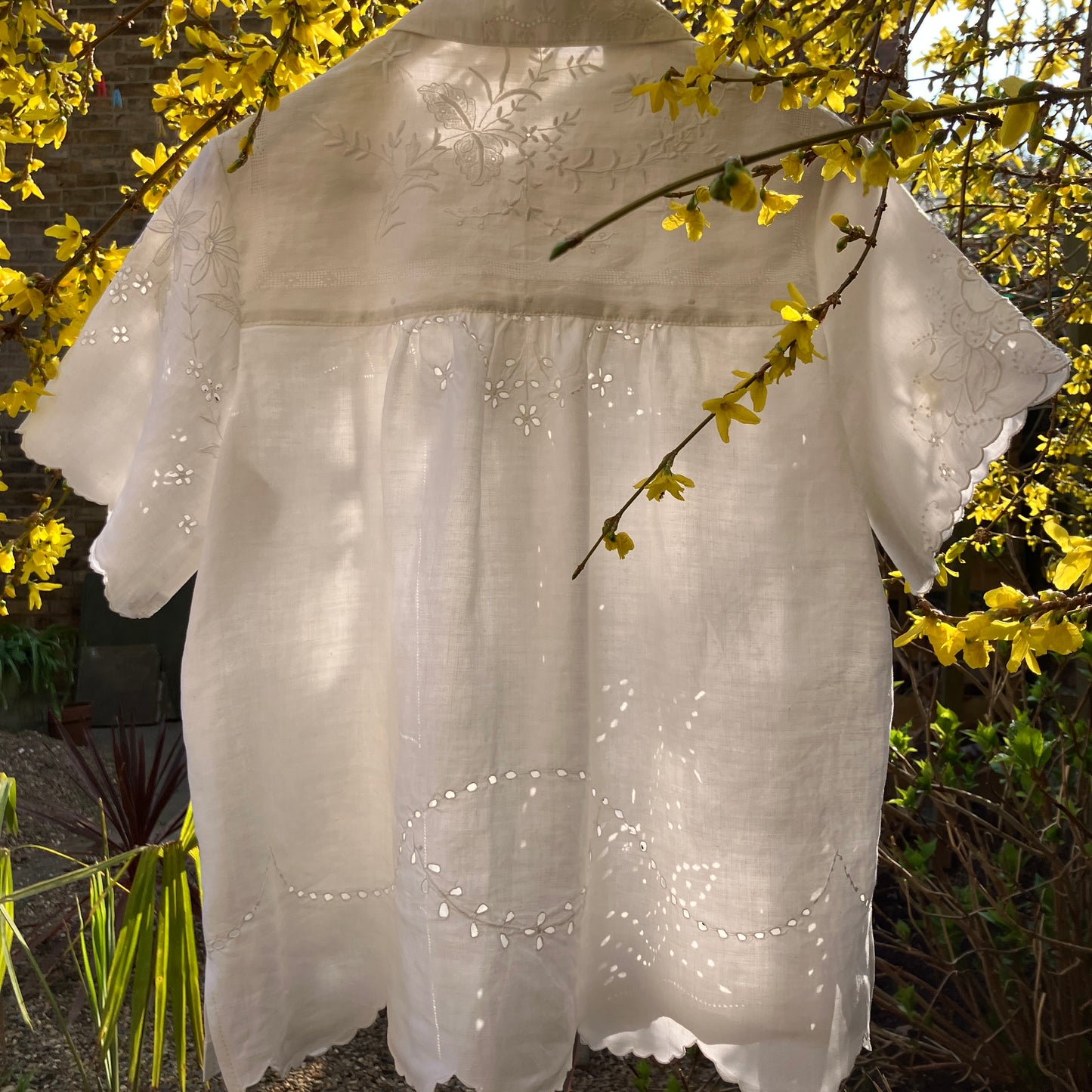 pretty, breezy blouse made from a
patchwork of reclaimed vintage cotton and linen white cutwork tablecloths.