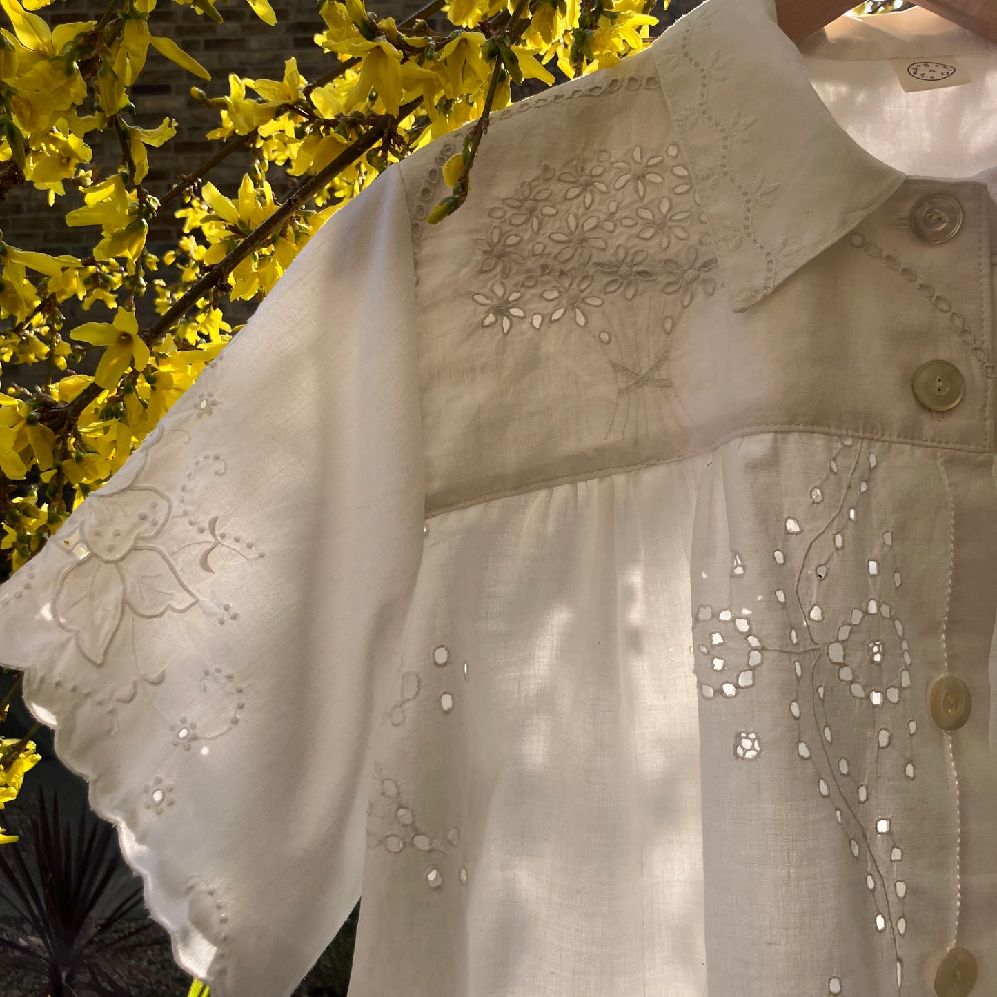 pretty, breezy blouse made from a
patchwork of reclaimed vintage cotton and linen white cutwork tablecloths.