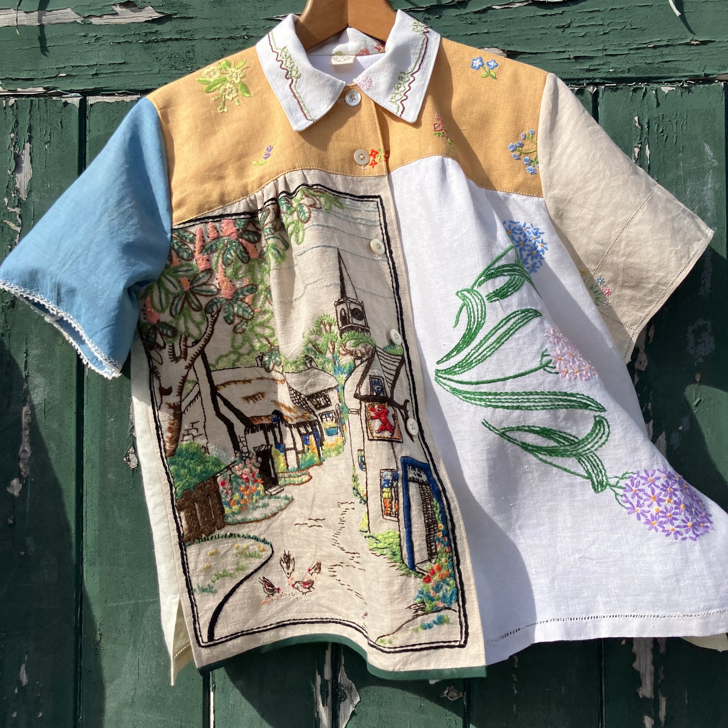 Recycled fabric shirt with embroidery depicting a village pub