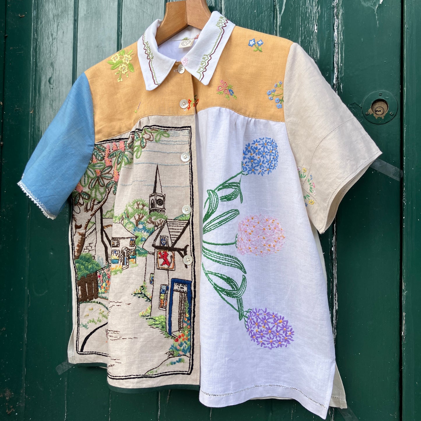 Recycled fabric shirt with embroidery depicting a village pub