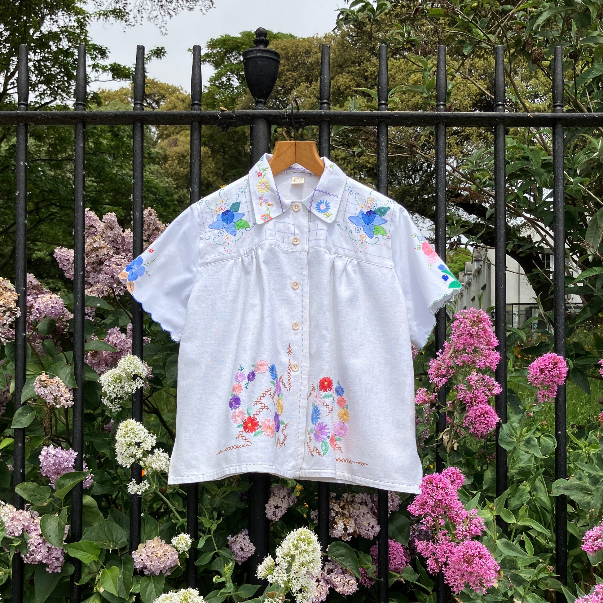 patchwork recycled tablecloth shirt hanging among some summer flowers