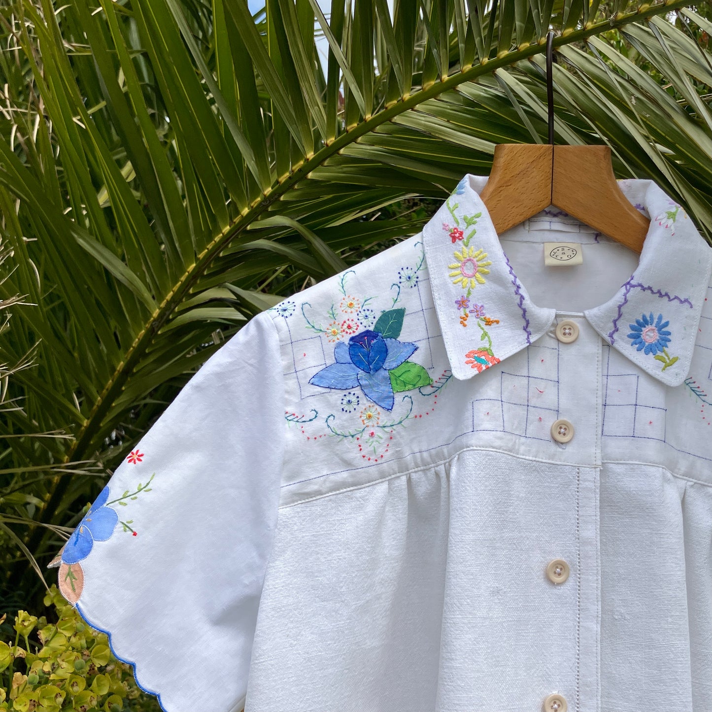 patchwork recycled tablecloth shirt hanging among some summer flowers