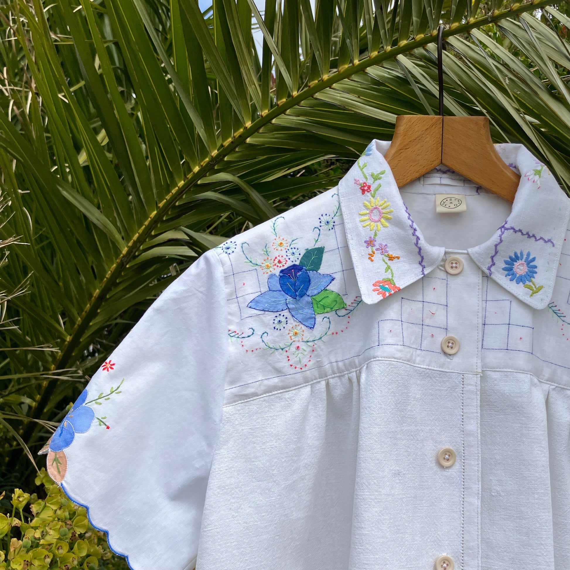 patchwork recycled tablecloth shirt hanging among some summer flowers