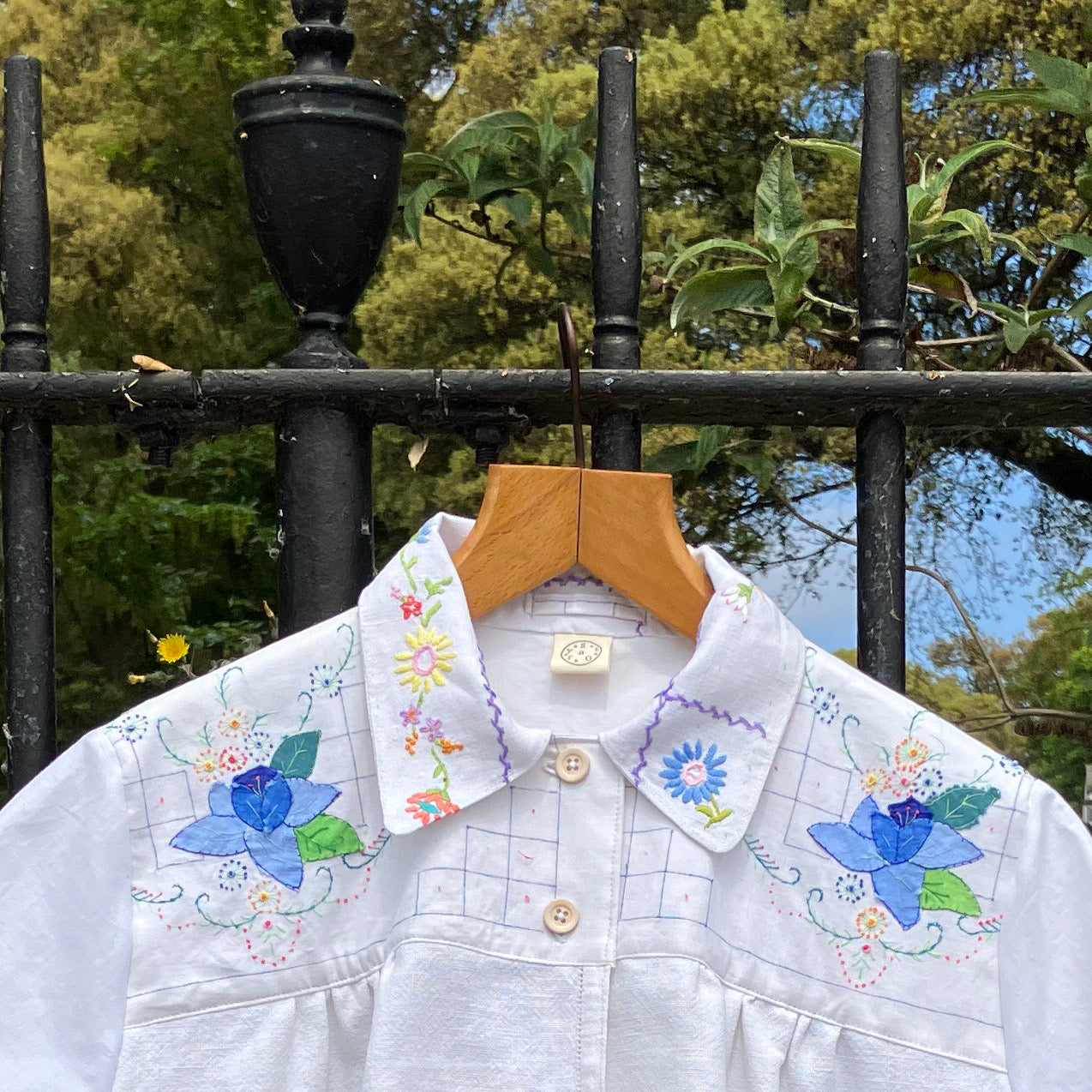 patchwork recycled tablecloth shirt hanging among some summer flowers