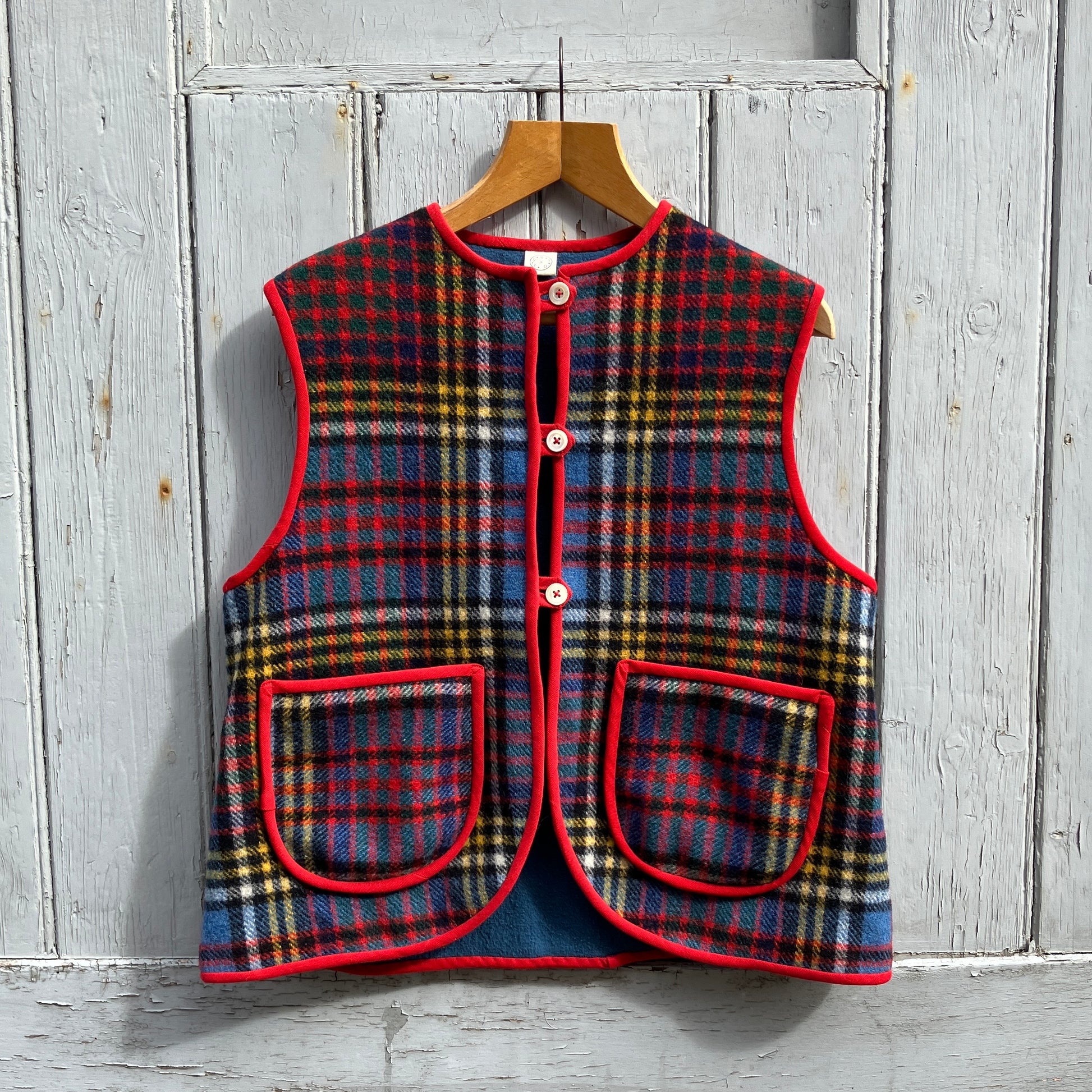 Vest/waistcoat/gilet handmade from a recycled tartan wool blanket. With red binding, two patch pockets and three shell buttons