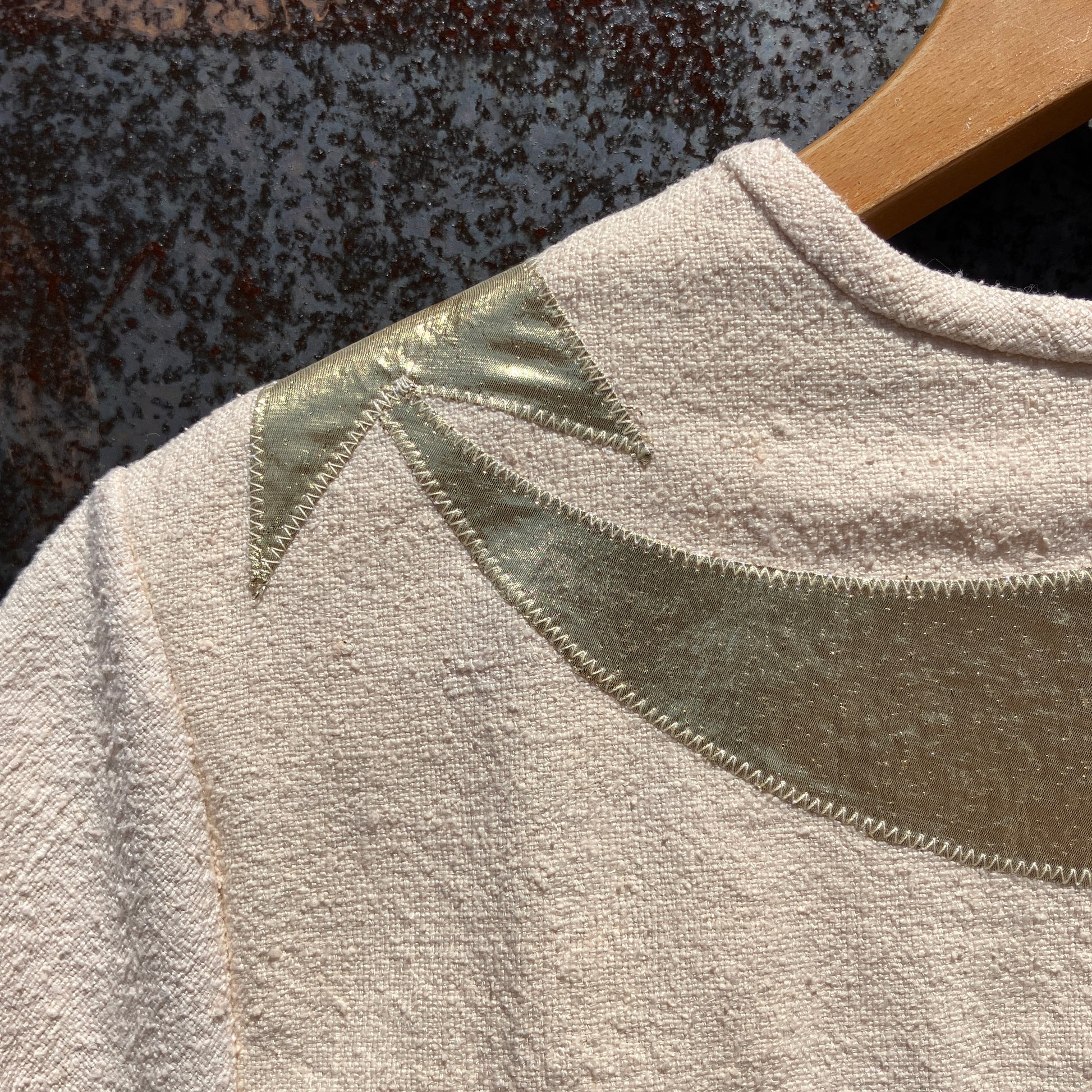 neutral-coloured raw silk smock with gold weather-themed appliqué