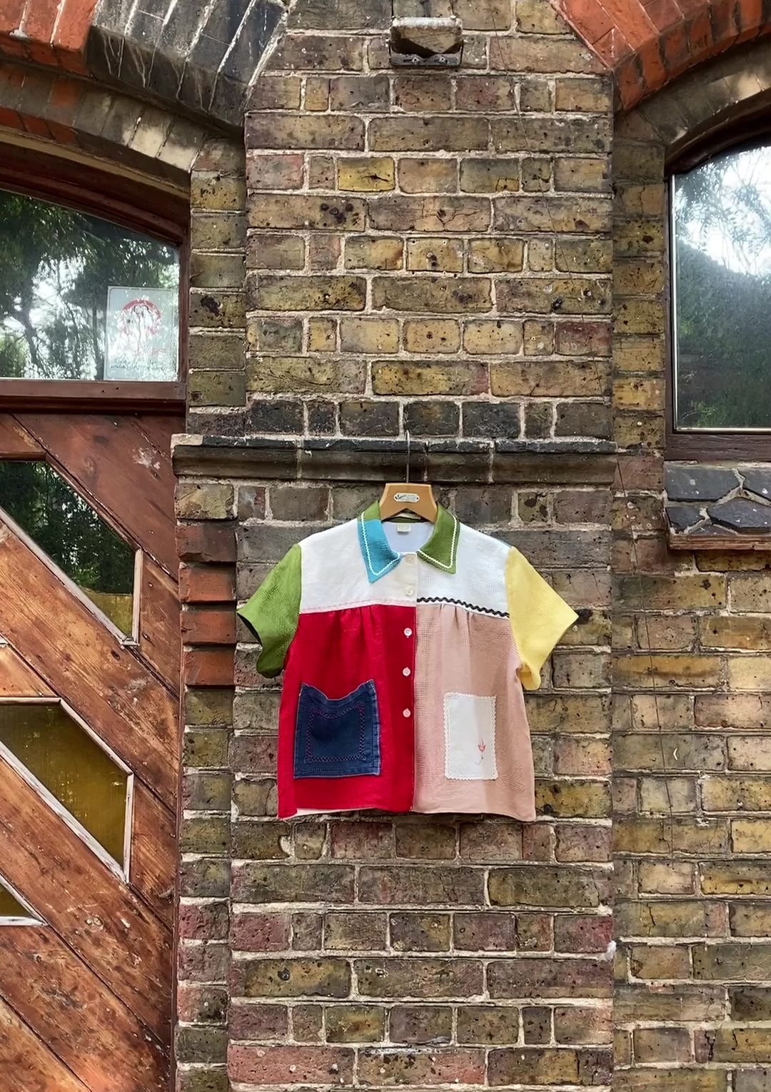 Short-sleeved shirt made from a patchwork of multicoloured vintage linen napkins (short video of it blowing in the breeze, hanging against an old fashioned brick wall)