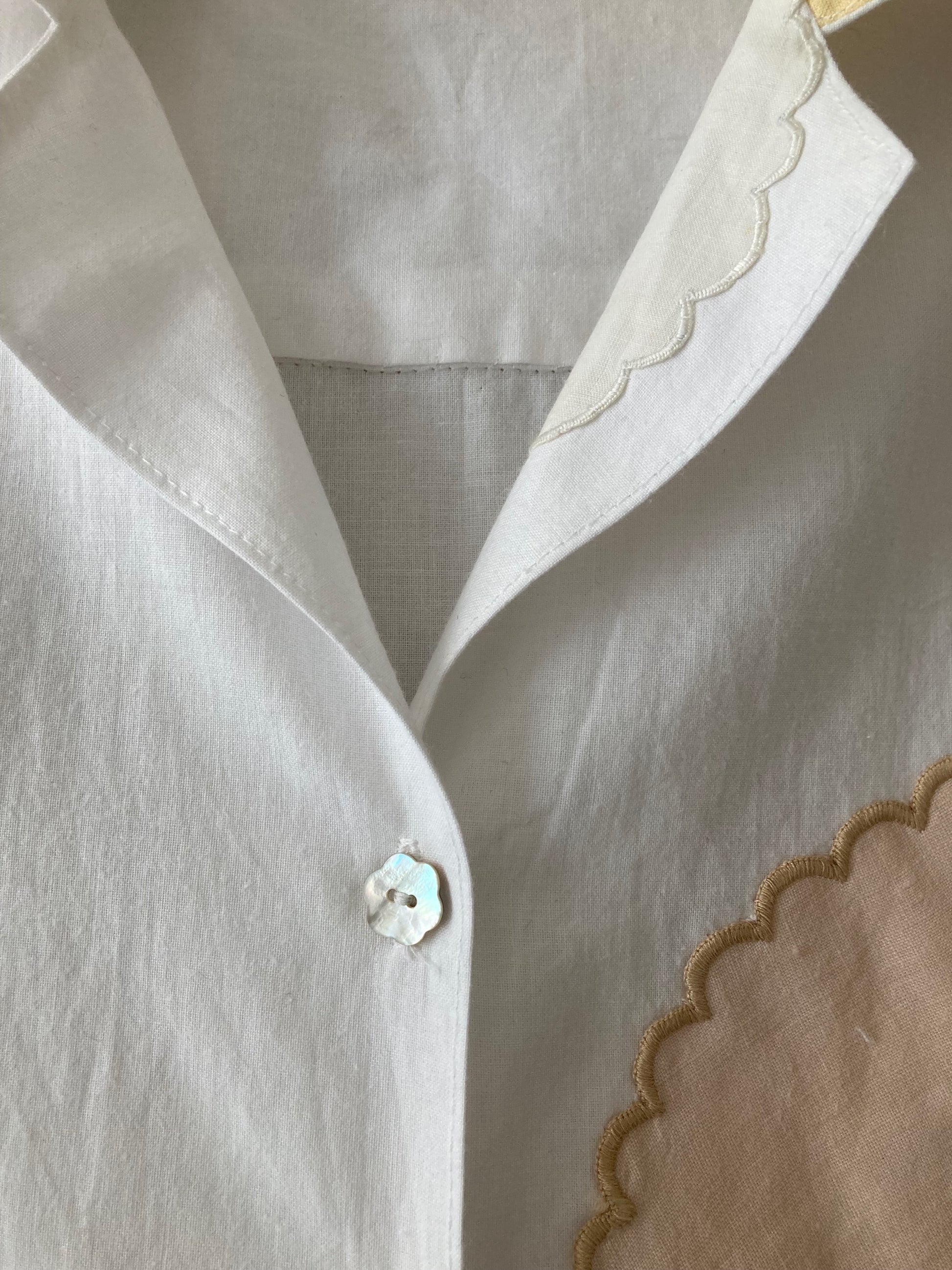 Handmade boxy shirt decorated with appliqué scallop-edge doilies, close-up