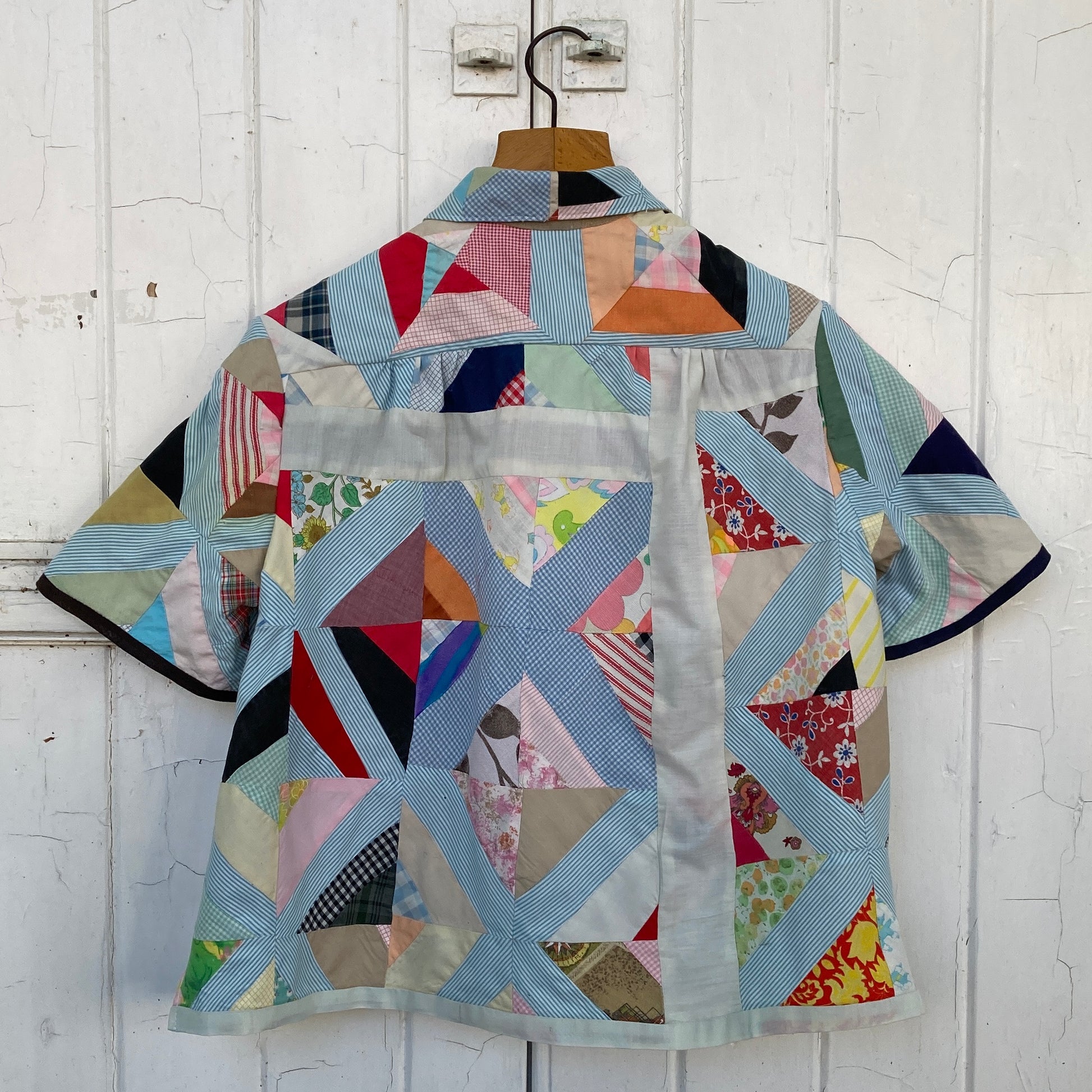 Short-sleeved shirt made from a found piece of 60s/70s patchwork in various bright and pastel colours (back view)