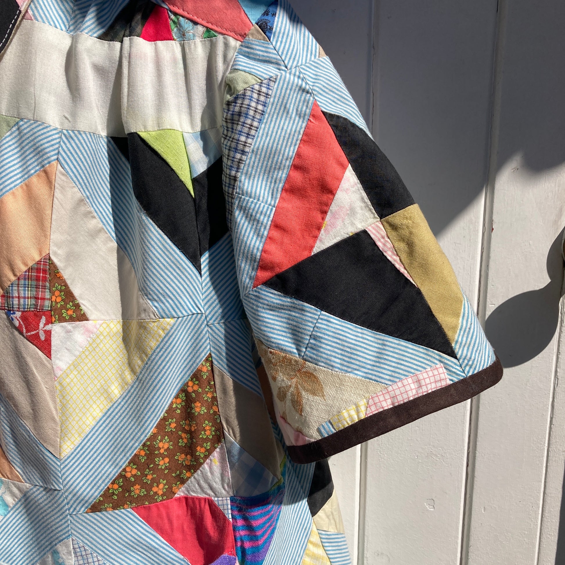 Short-sleeved shirt made from a found piece of 60s/70s patchwork in various bright and pastel colours (close-up of sleeve)