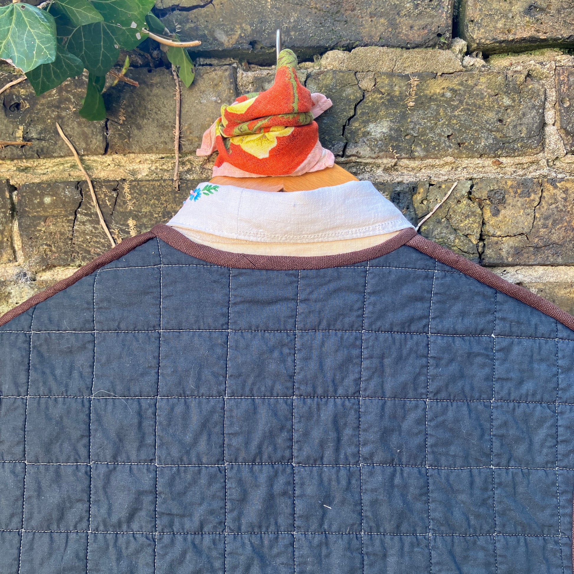 Super useful vest/gilet/bodywarmer/waistcoat handmade from a reclaimed black cotton quilt. Features two large patch pockets, three found shell buttons and brown linen binding.