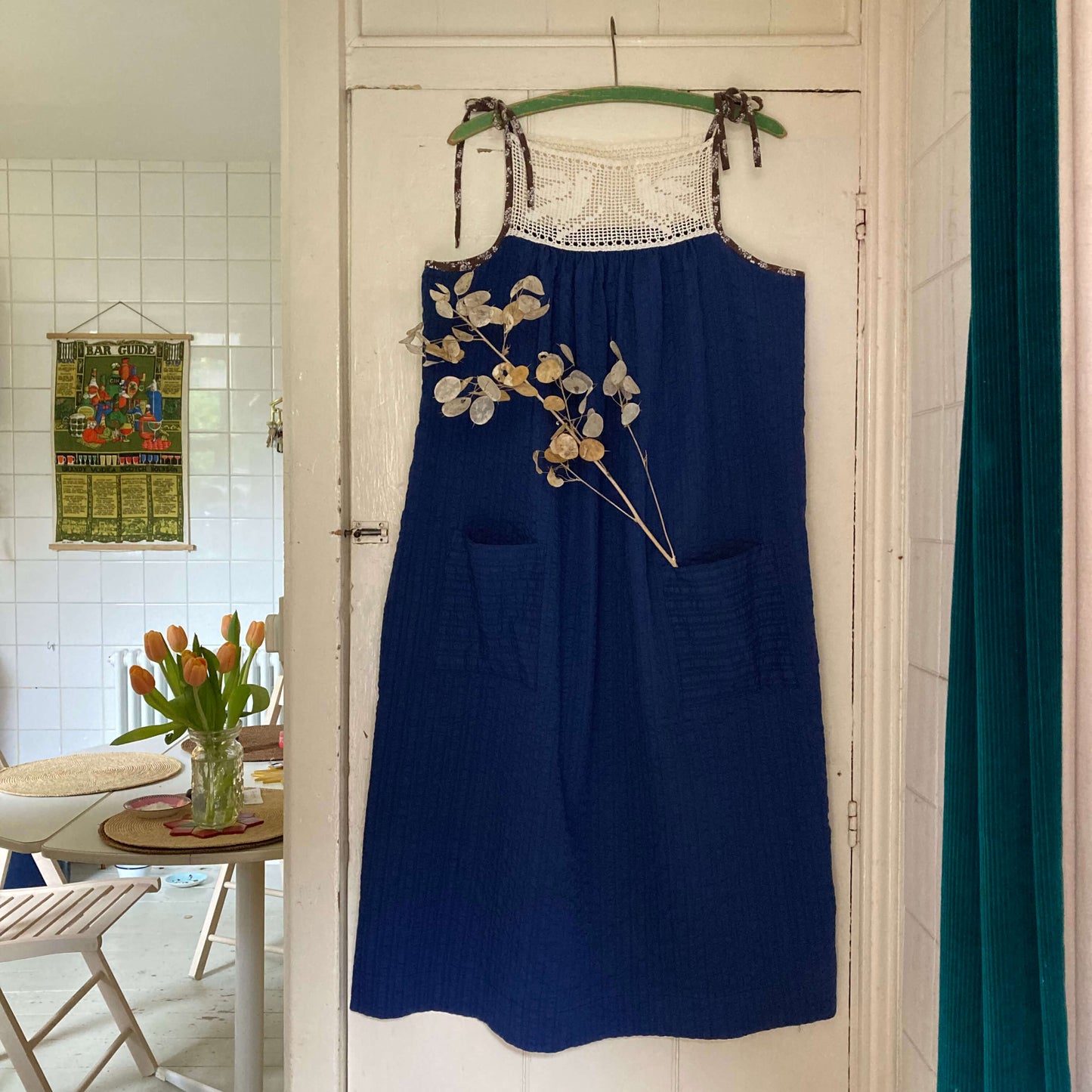 Hand stitched blue and white light and airy summer dress made from recycled cotton seersucker with a vintage bird-motif crochet yoke, tie straps and two patch pockets