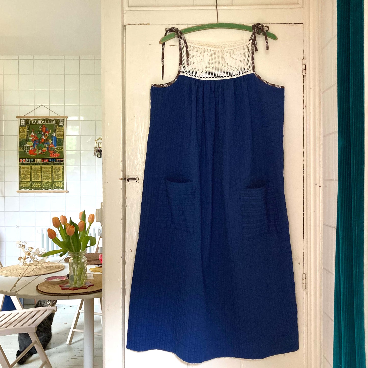 Hand stitched blue and white light and airy summer dress made from recycled cotton seersucker with a vintage bird-motif crochet yoke, tie straps and two patch pockets